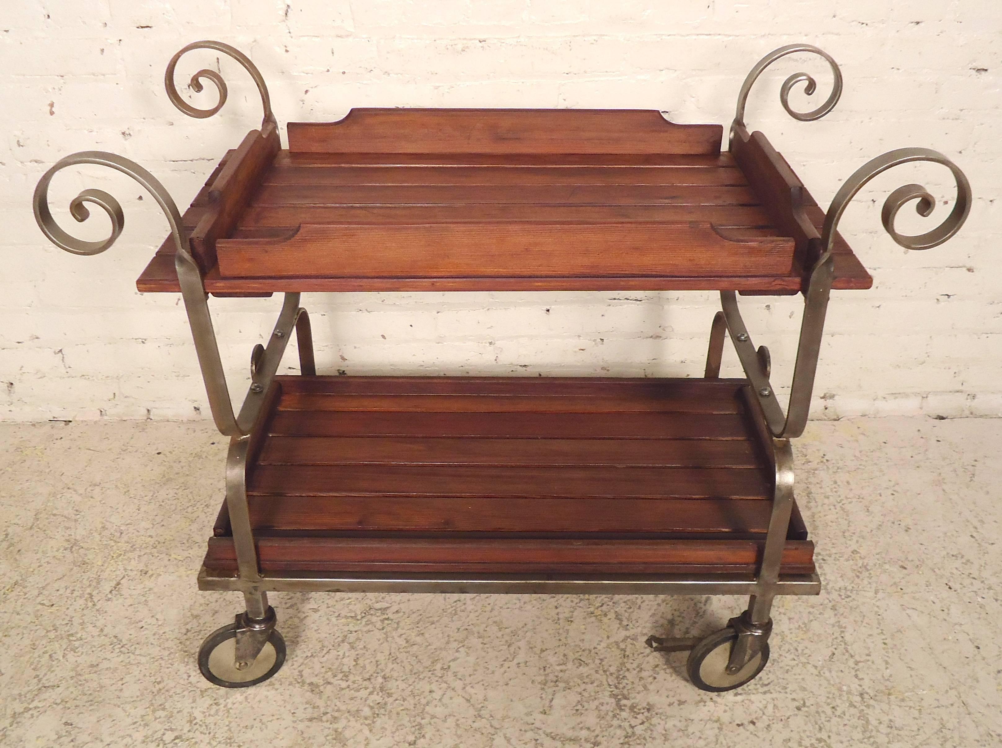 Vintage tea cart with removable wood trays set in metal frame with large casters. Metal has been restored in a bare metal style finish, and features lovely embellishments.

(Please confirm item location - NY or NJ - with dealer).
      