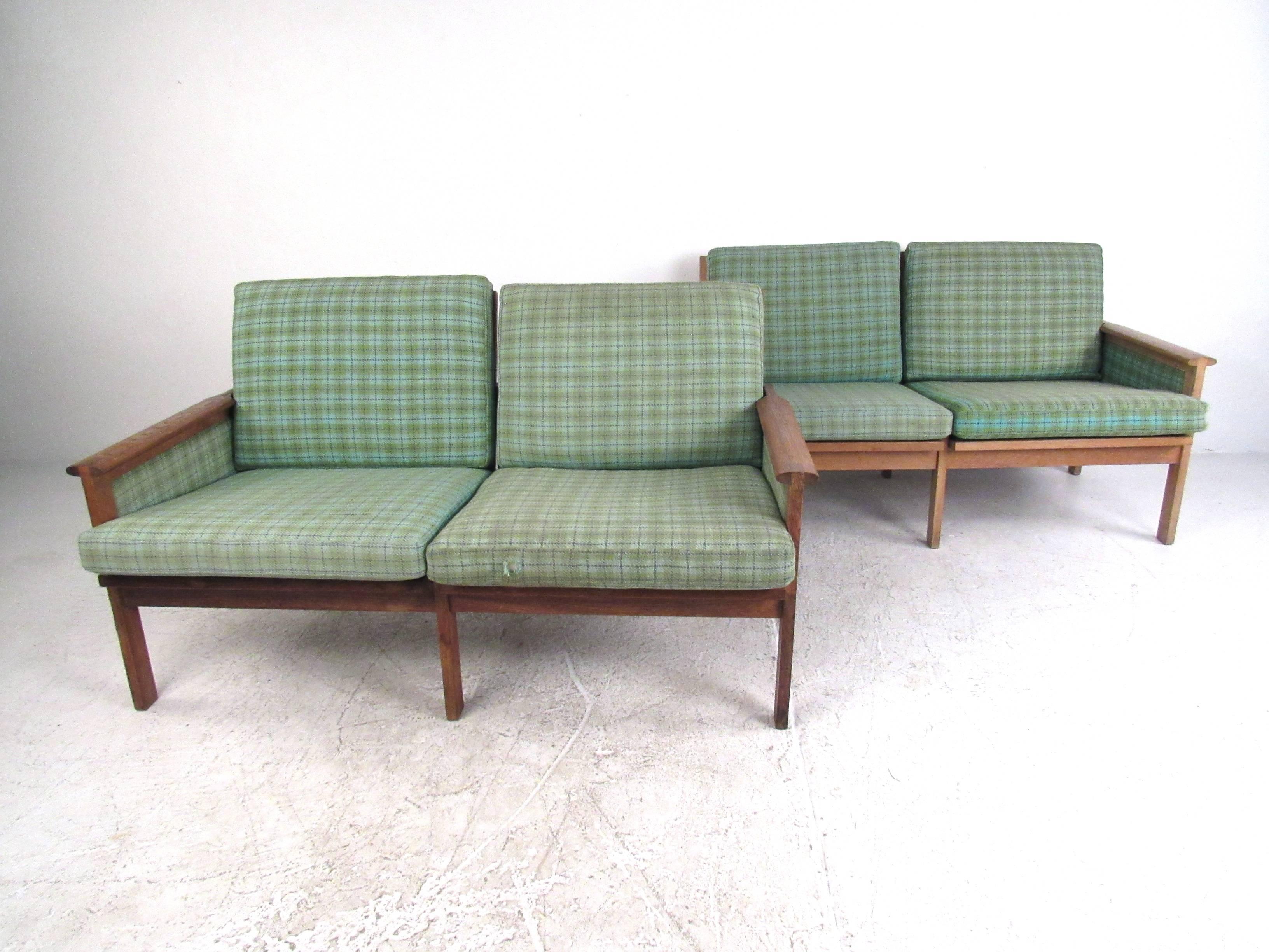 This stunning pair of vintage Danish teak settees make a beautiful Mid-Century addition to seating at home, office, or business. Unique upholstered frames, sculpted armrests, and versatile size make this matching pair the perfect set for rounding