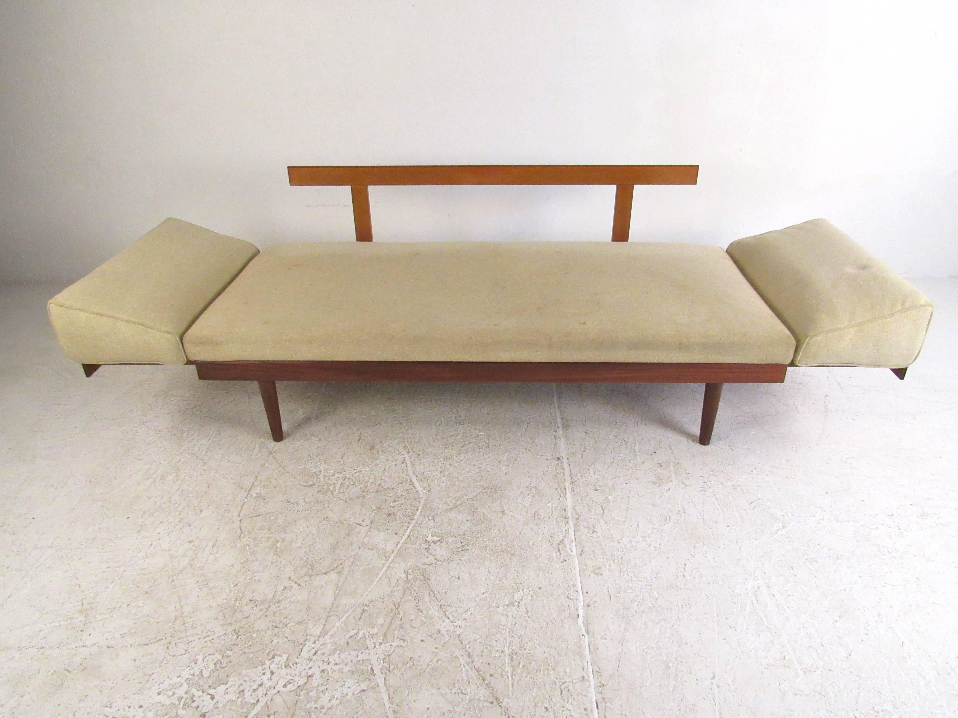 This beautiful vintage daybed features subtle Danish modern style and offers unique slide-out teak end tables to allow conversion into a full length 90 inch wide daybed. Versatile Mid-Century seating for any interior! Please confirm item location