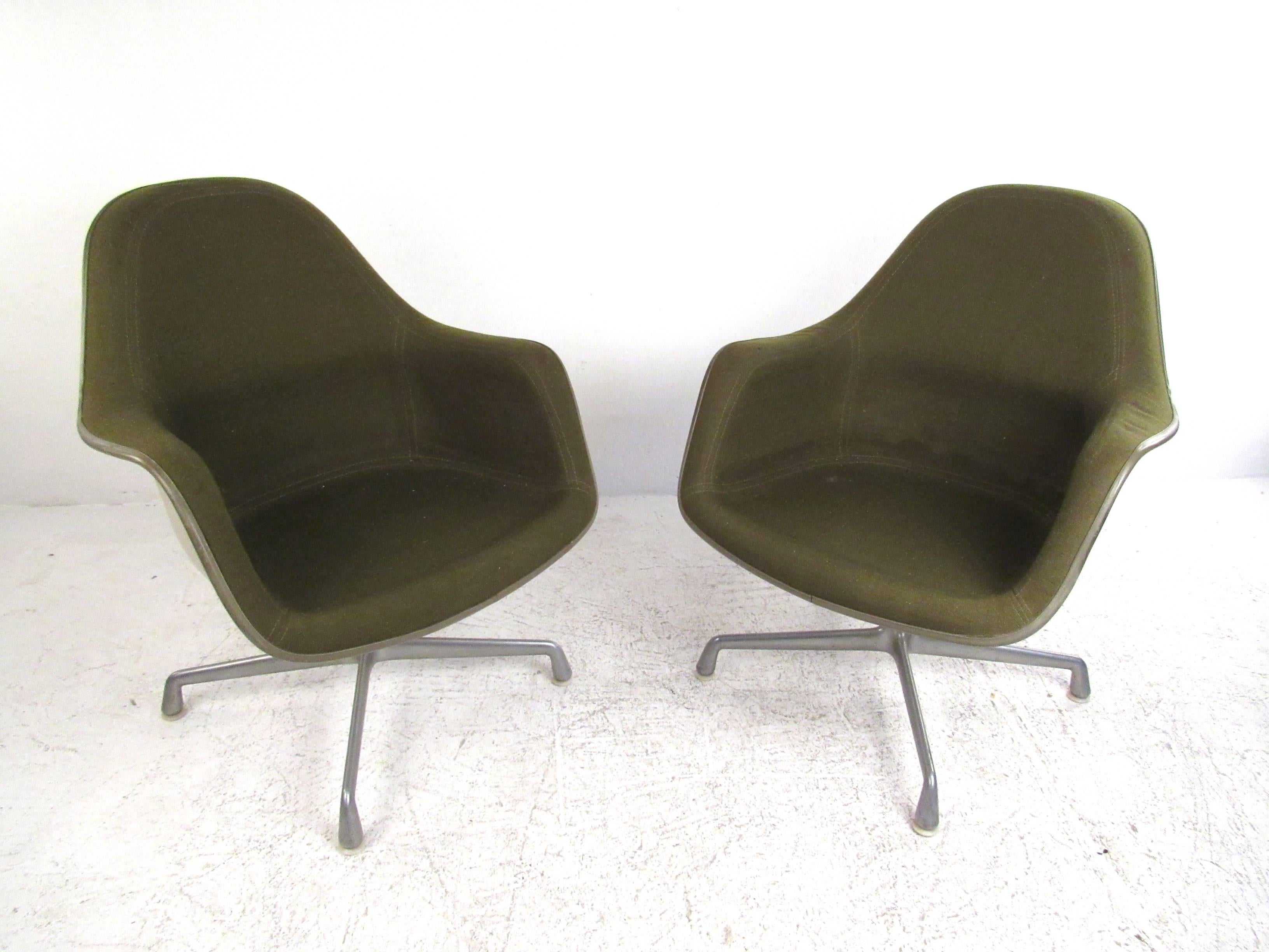This unique pair of Charles Eames vintage swivel chairs feature upholstered fiberglass seats set on sturdy aluminum swivel bases. Unique retro style makes this iconic pair of Herman Miller chairs a distinctive addition to any interior. Please