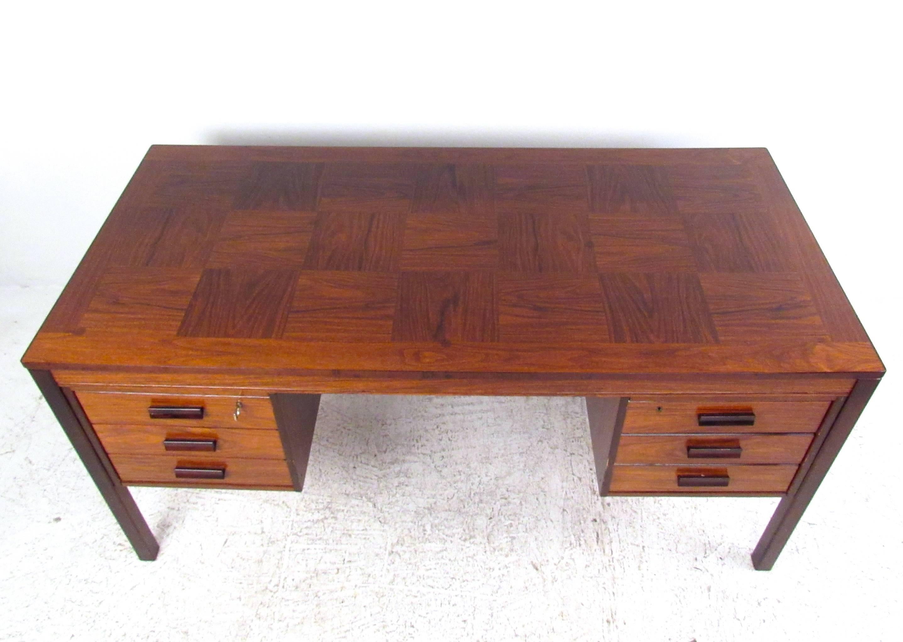 This beautiful vintage desk features unique two-tone construction including rosewood and teak components. Locking drawers (key included), sculpted handles and wonderful marquetry top add to the vintage charm of this Mid-Century writing desk. Please