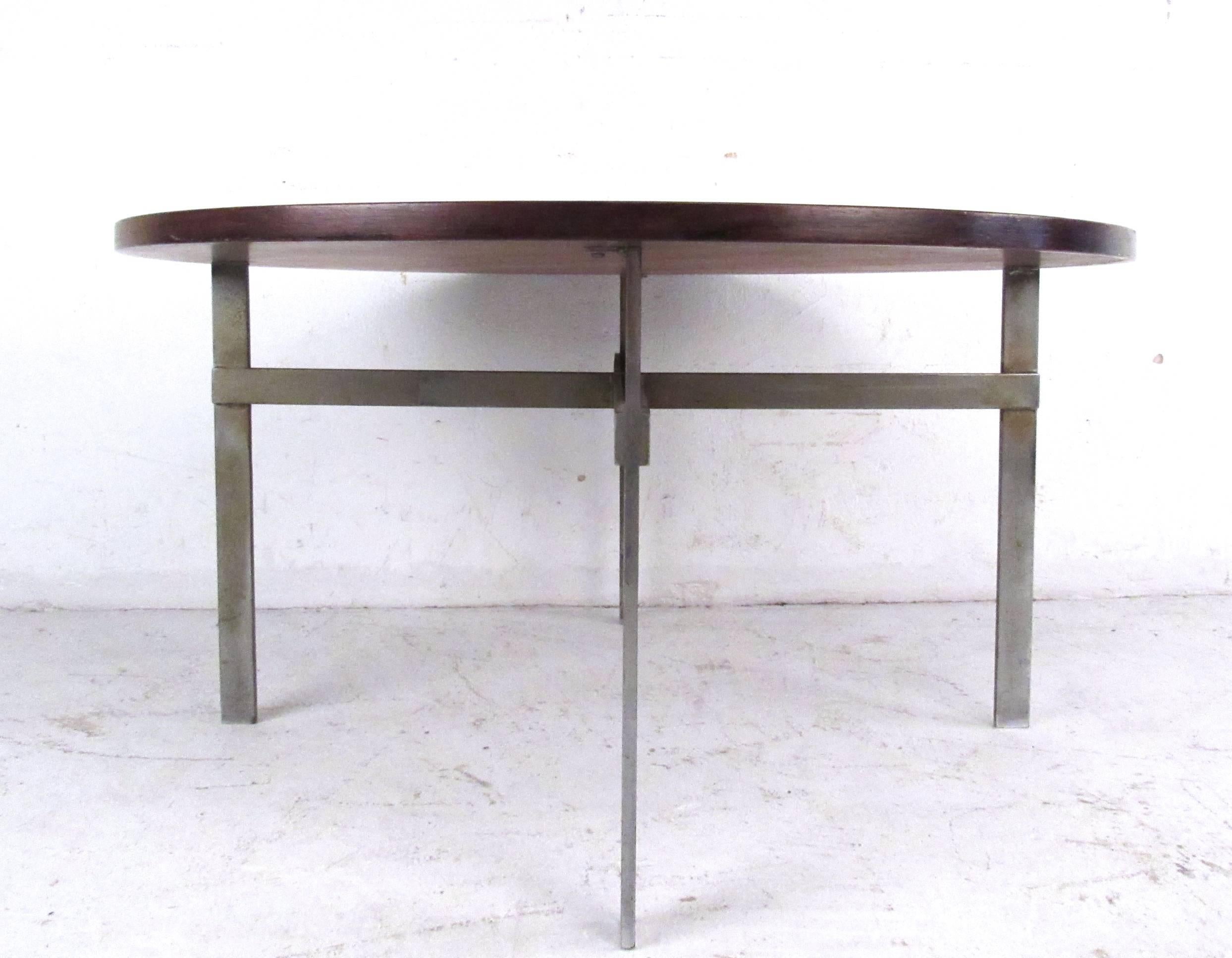 This unique Mid-Century rosewood cocktail table makes a unique circular coffee table in a variety of settings. Stylish Mid-Century Modern design with flat metal frame and added cross beams for style and support. Please confirm item location (NY or