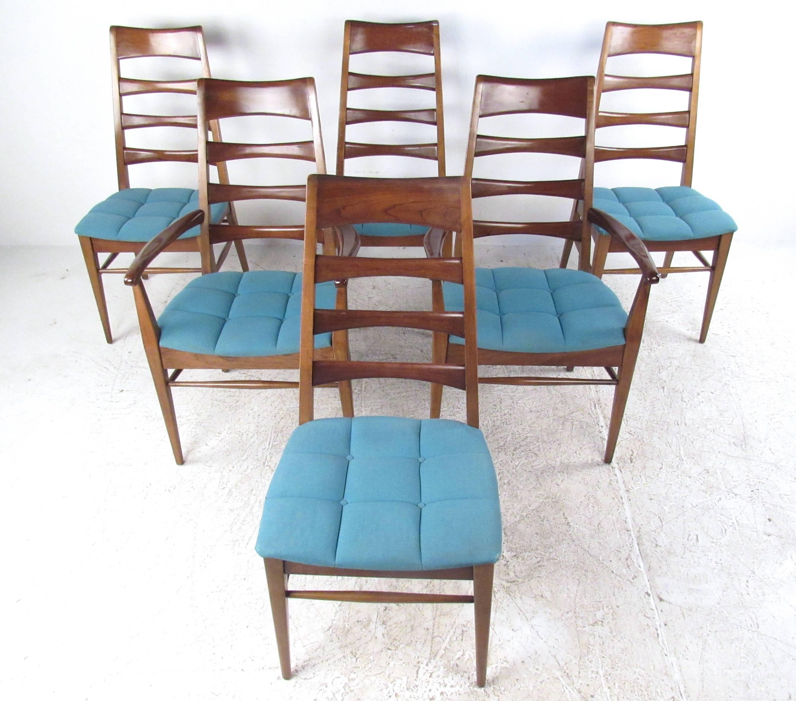 This vintage set of high back dining chairs is still matched with a stunning Mid-Century table. Upholstered seats and stylish sculpted seat backs are complimented by the rich finish of this hardwood set. Set of six chairs includes two armchairs,