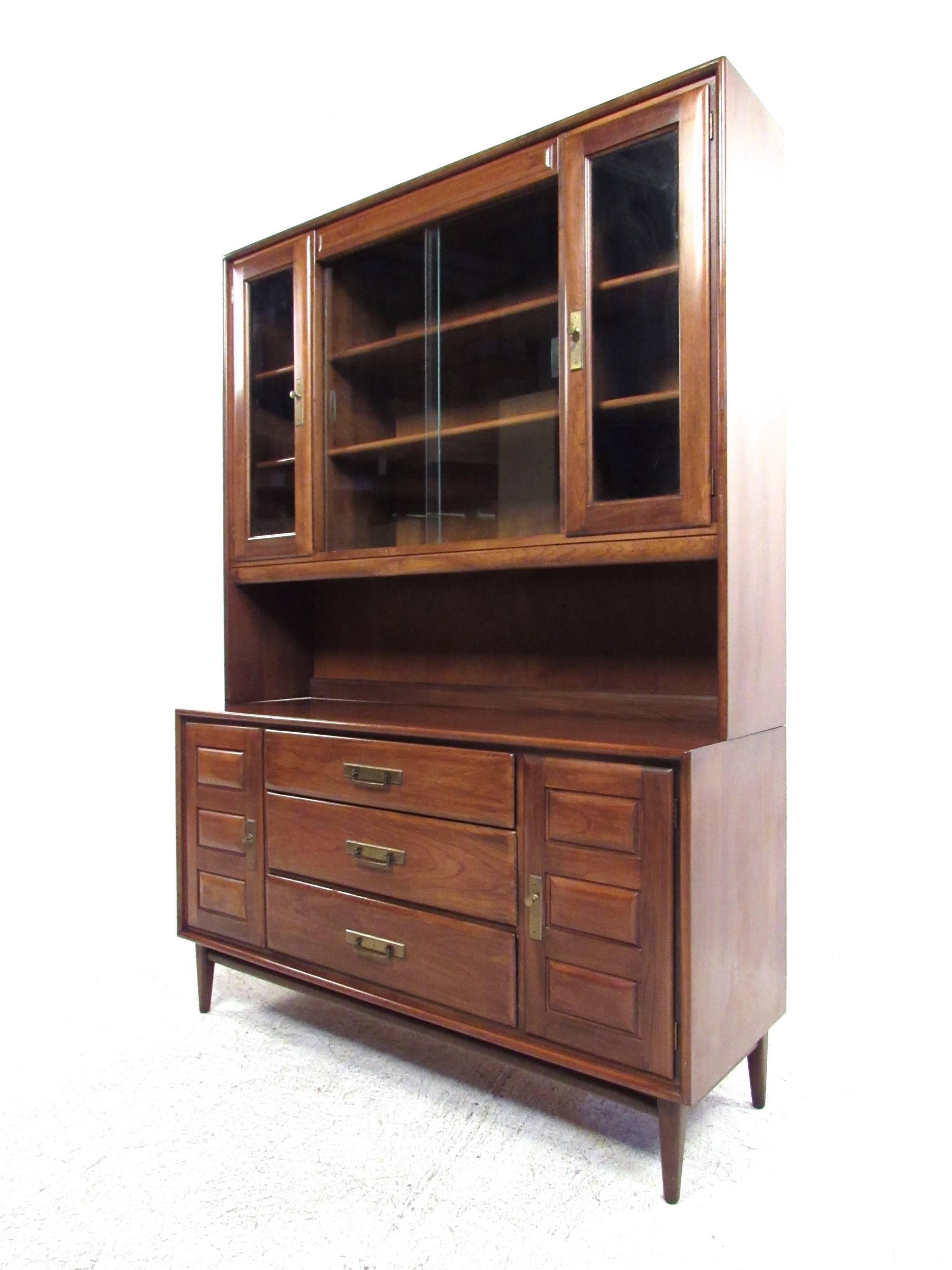 This beautiful vintage sideboard offers plenty of storage and display space with its matching display hutch. Brass trim, tapered legs and clean Mid-Century lines add to the vintage appeal of the piece. Matching dining room table, chairs and credenza