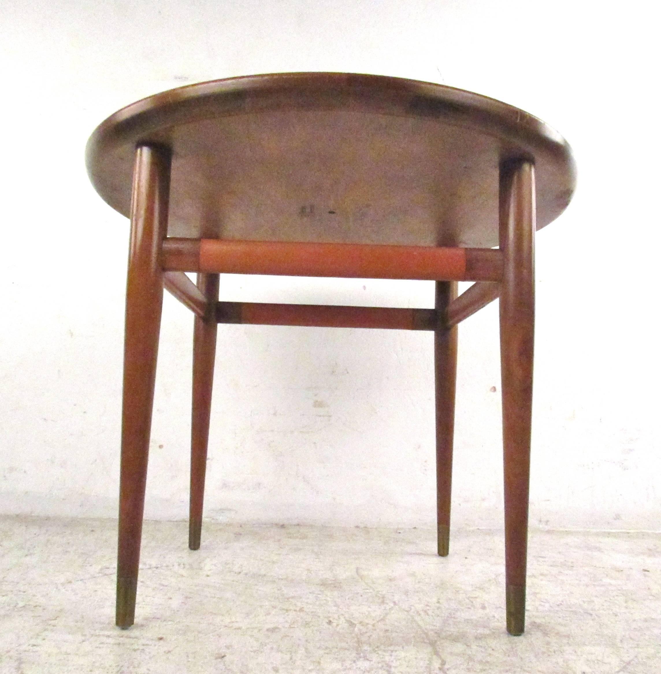 This unique leather top end table features stylish Mid-Century details including turned edge leather top, tapered legs and leather wound stretchers. This Henredon table is the perfect size to compliment seating area in home or office. Please confirm