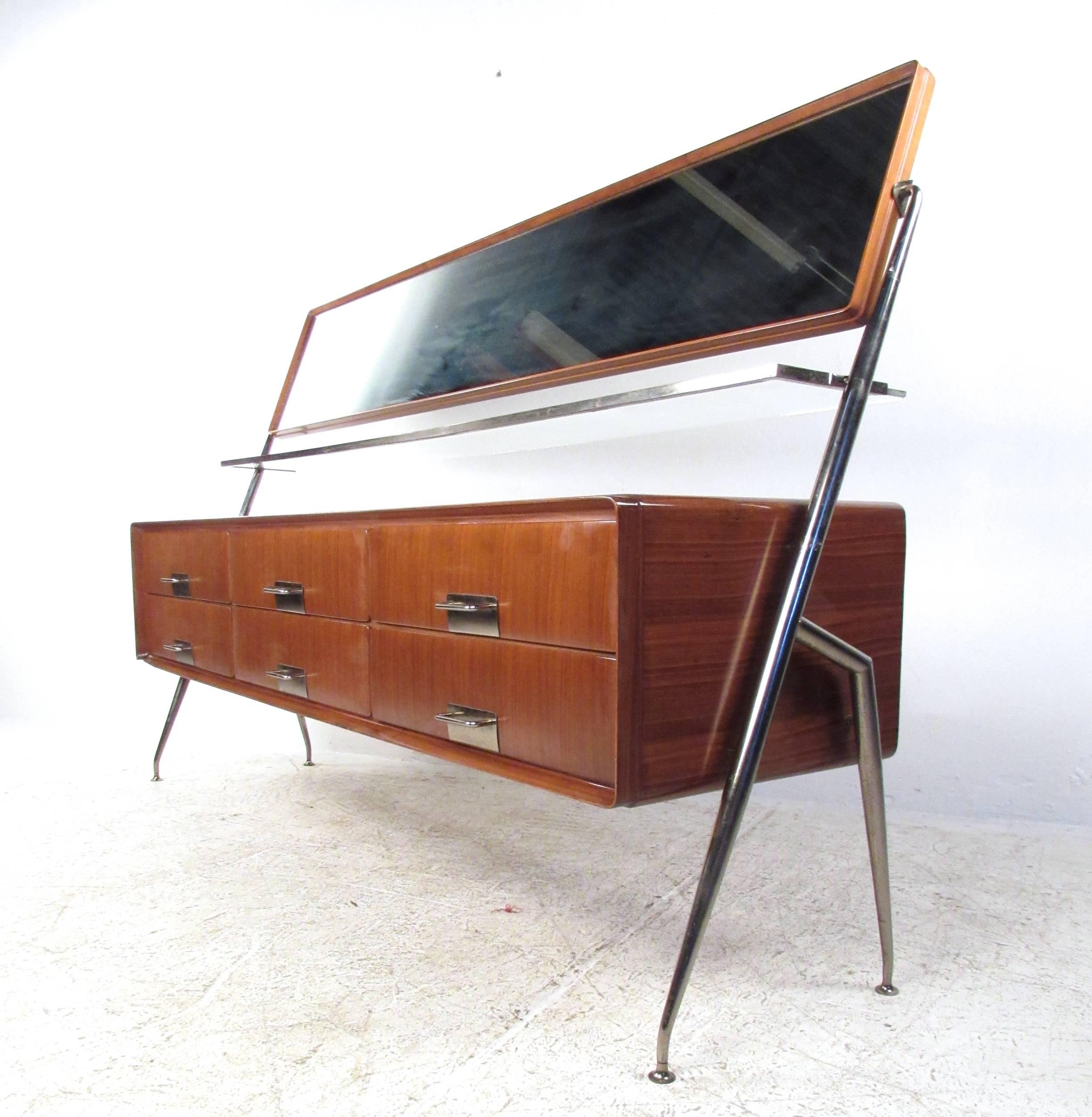 This stunning vintage dresser features a stylish mis of wood, glass, and metal. Tapered geometric frame, beautiful vintage finish, and adjustable vanity mirror set this piece apart from other Mid-Century selections. Definitive Italian design makes