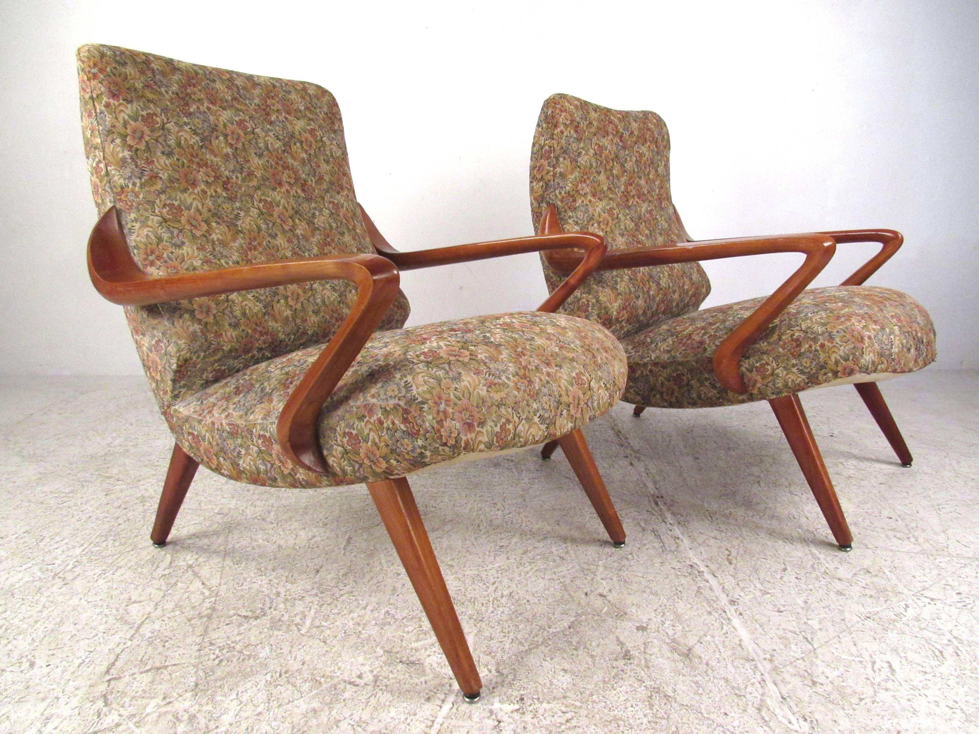 This incredible pair of sculptural lounge chairs features truly unique sculpted wood frames with sleek upholstered seats. Tapered legs and vintage floral fabric add to the Mid-Century Italian charm of the pair. Please confirm item location (NY or