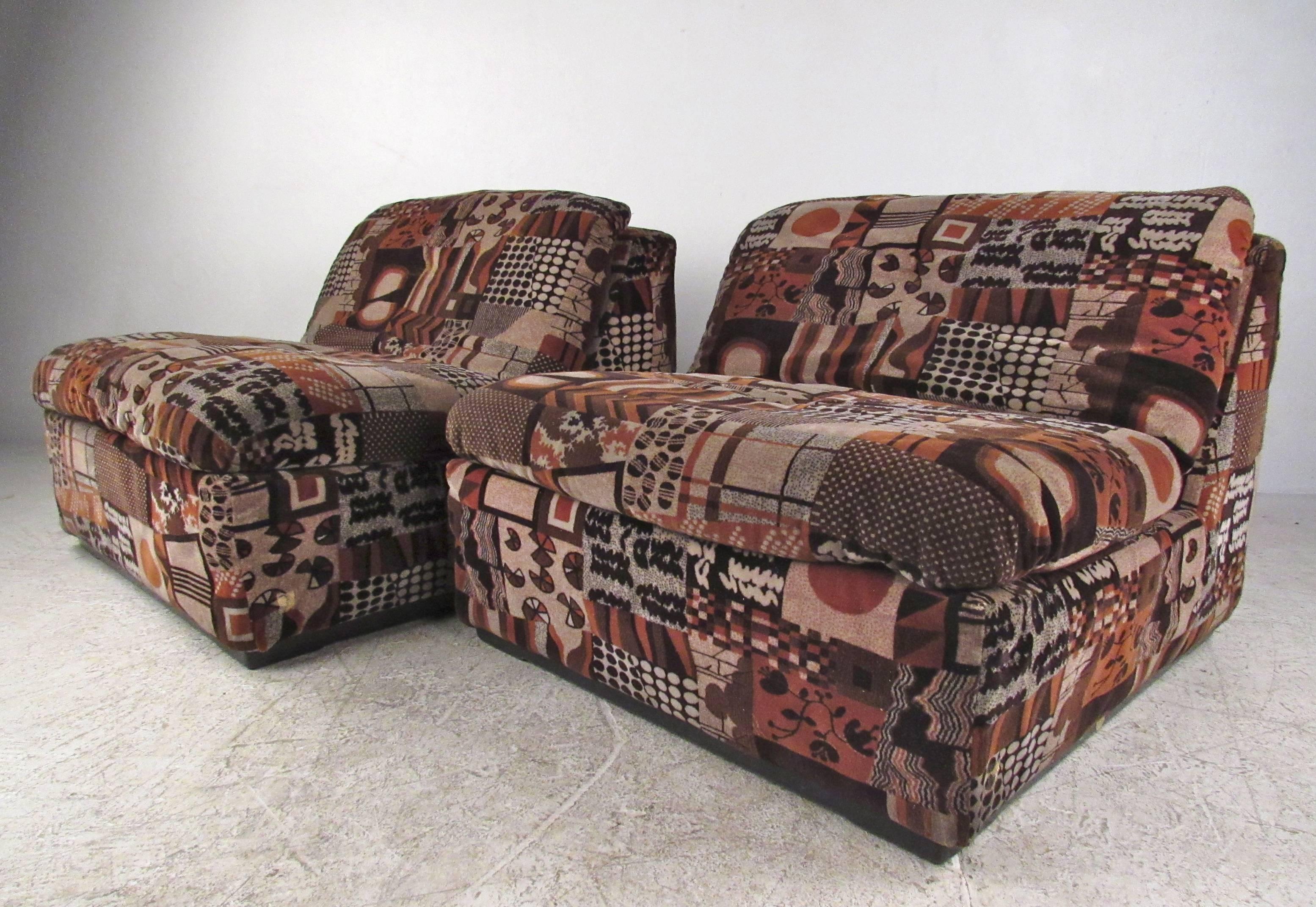 This unique vintage pair of low slung lounge chairs features wild vintage fabric on a comfortable upholstered frame. Uniquely angled with plenty of padding these impressive Mid-Century chairs make an unforgettable addition to any interior. Please