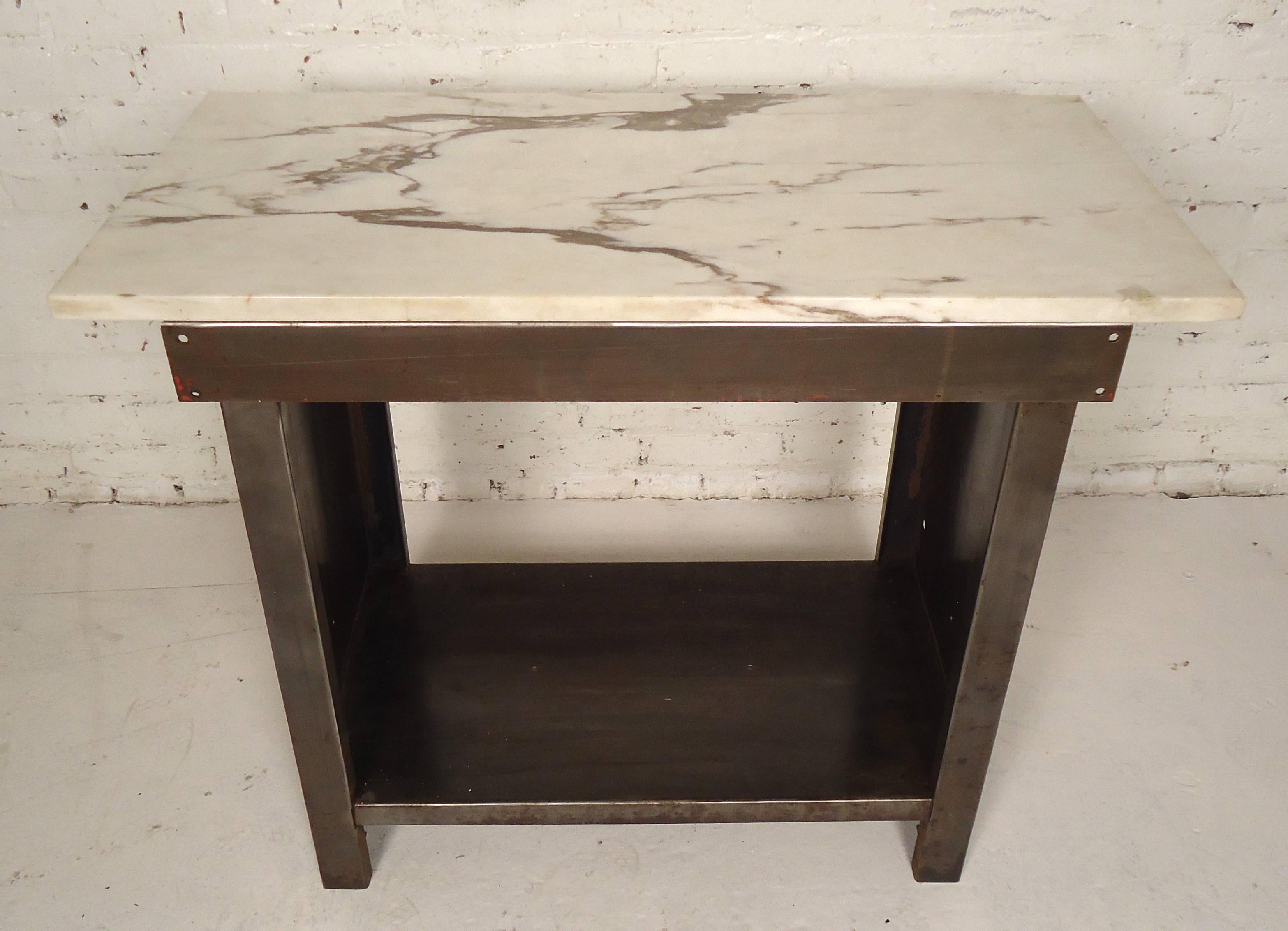 Industrial metal table featuring marble top and shelving. Stripped to a bare metal Industrial style finish. Perfect piece for your kitchen or bathroom. 

 Please confirm item location (NY or NJ).