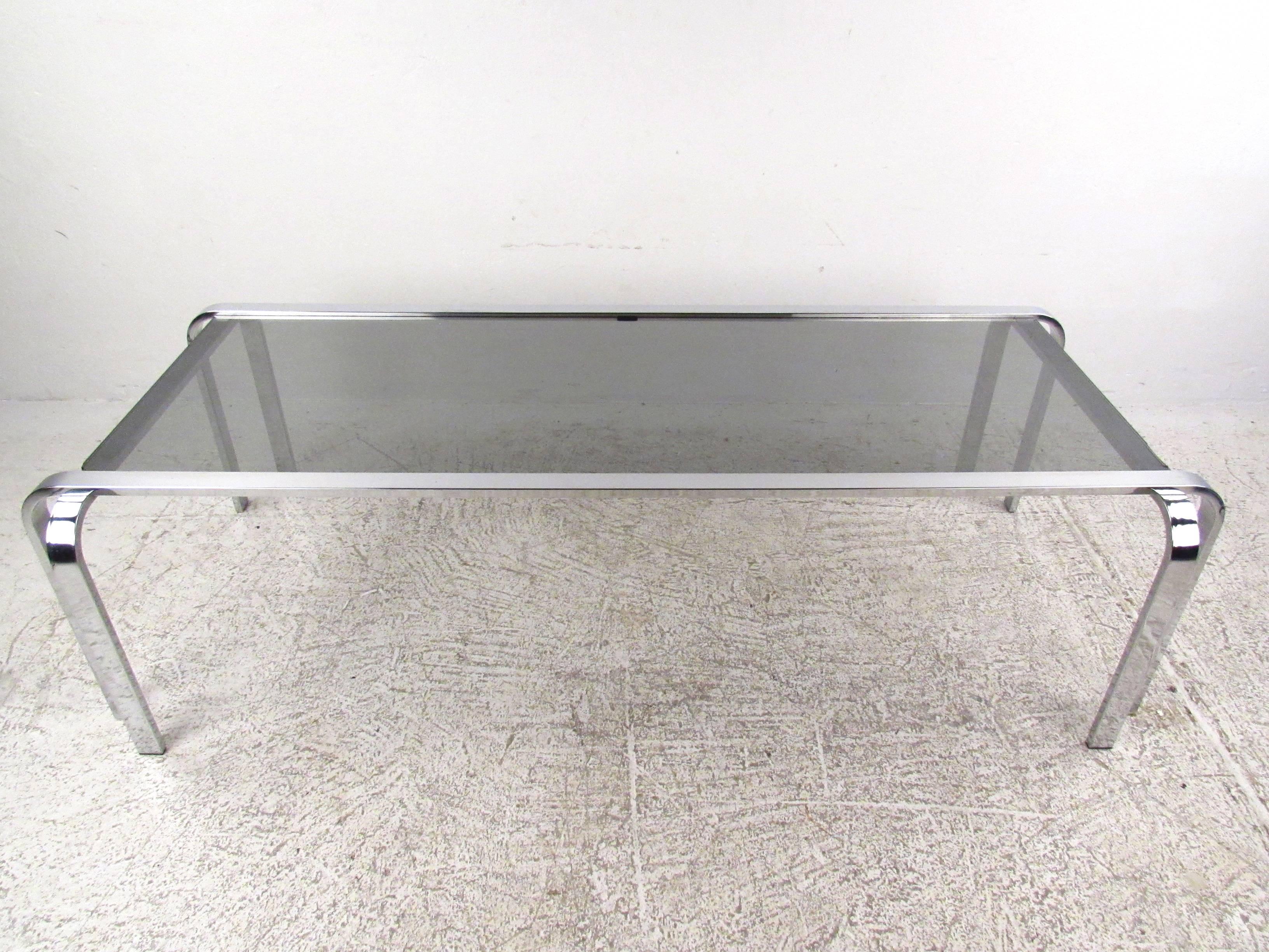 This stunning vintage chrome coffee table features uniquely designed metal frame with rounded corners and stylish double leg design. Glass top compliments the simplistic modern design of the piece and makes it a great addition to any interior.