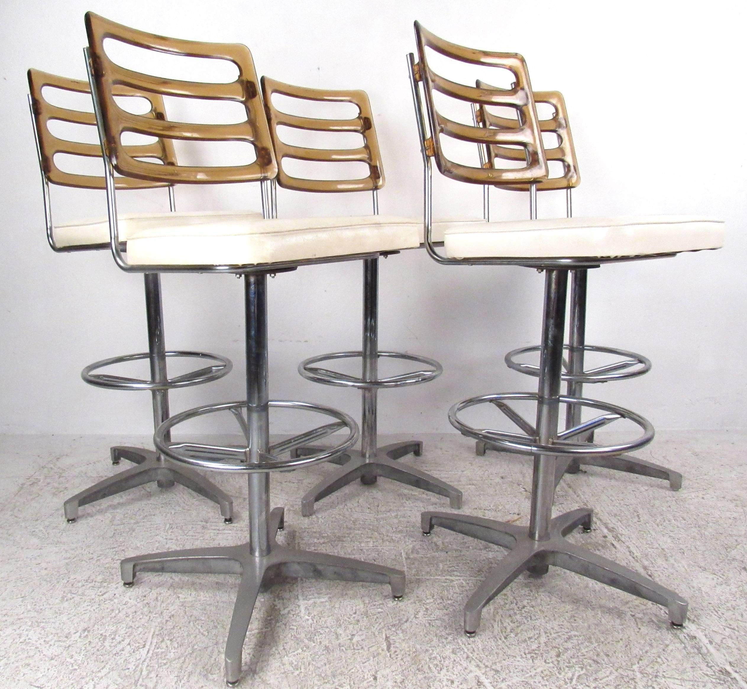 This beautiful vintage set of five Lucite and vinyl bar stools features an aluminum swivel base with a round chrome foot rest. The unique tinted Lucite back rest adds style and grace in any setting. Please confirm item location with dealer (NY or