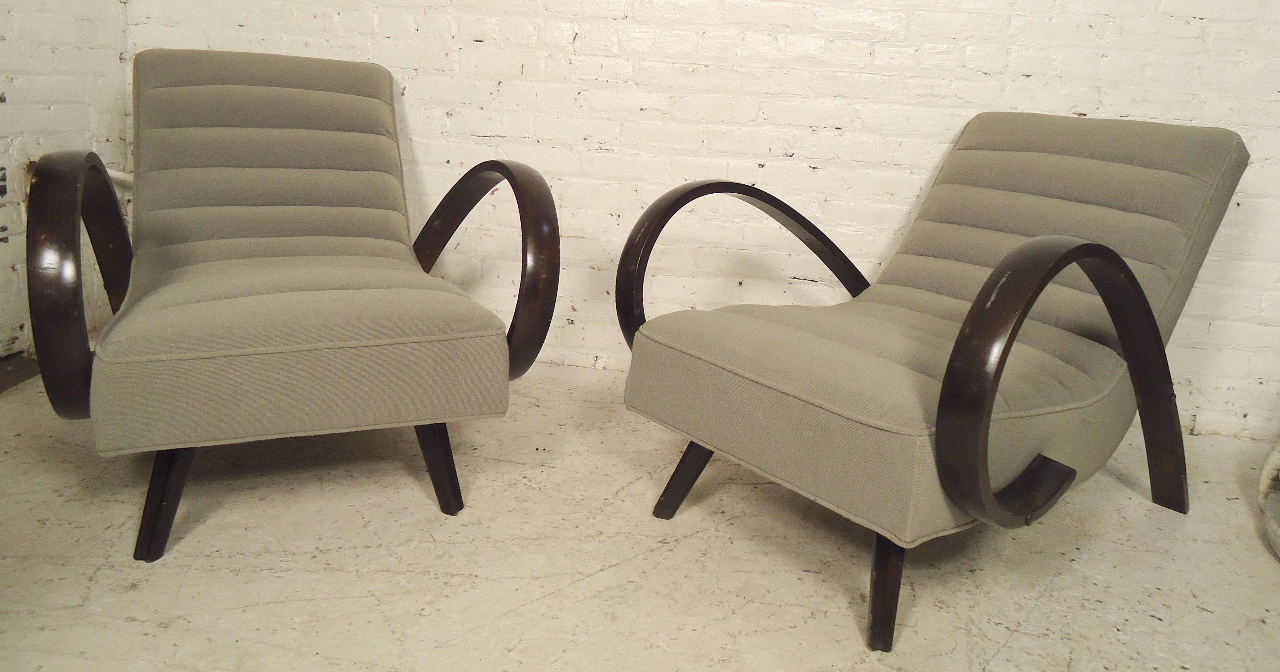 Pair of striking Mid-Century style armchairs with swooping wood arms that flow to the back. Distinct modern style with comfortable cushioned seating.

(Please confirm item location - NY or NJ - with dealer).
 