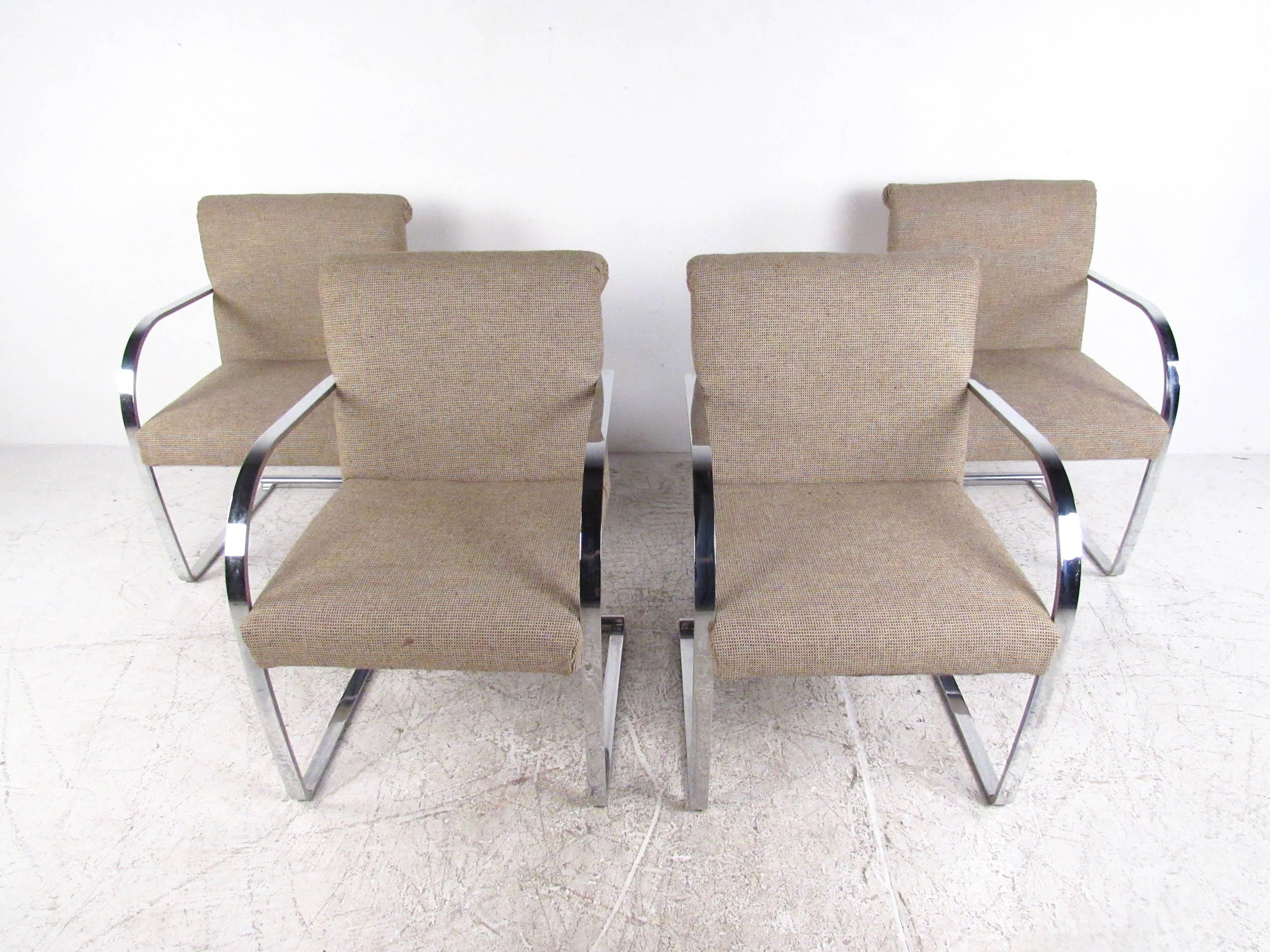 This set of four vintage dining chairs features unique flat chrome frame cantilever design, with rounded armrests, and comfortably padded seats. Unique scrolled top seat back and stunning chrome finish add to Mid-Century charm of the set, with