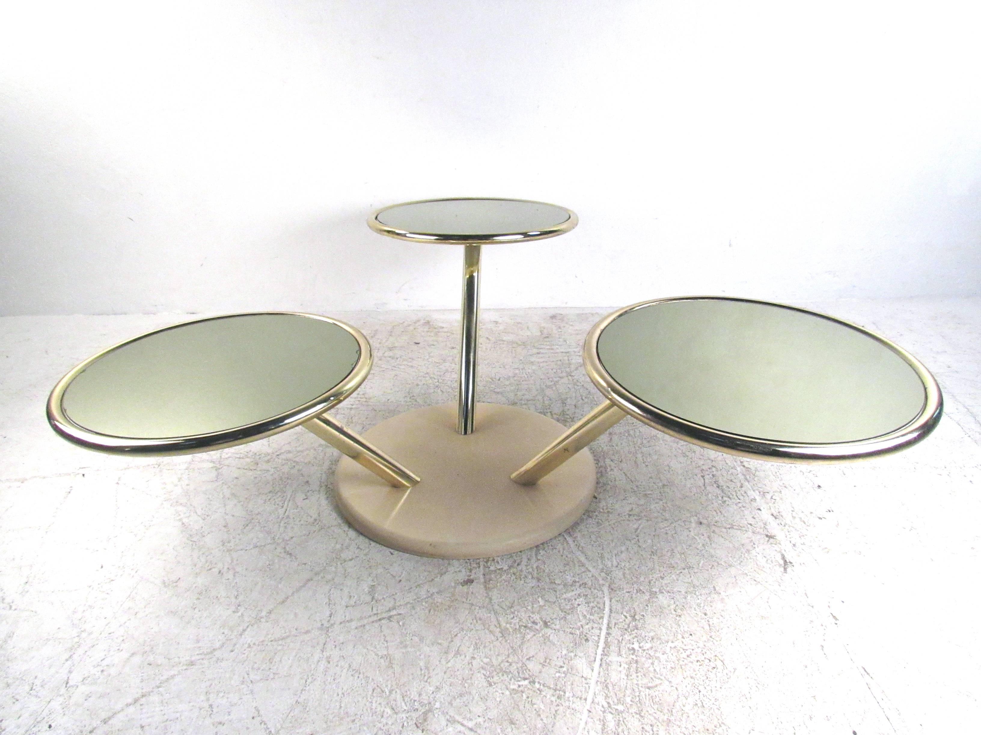This beautiful vintage three-tier swivel table features unique brass frame with mirrored glass table tops. Stylish design allows three tables to be swung in to the middle or out for a wider table top area. Stylish and impressive, this Mid-Century