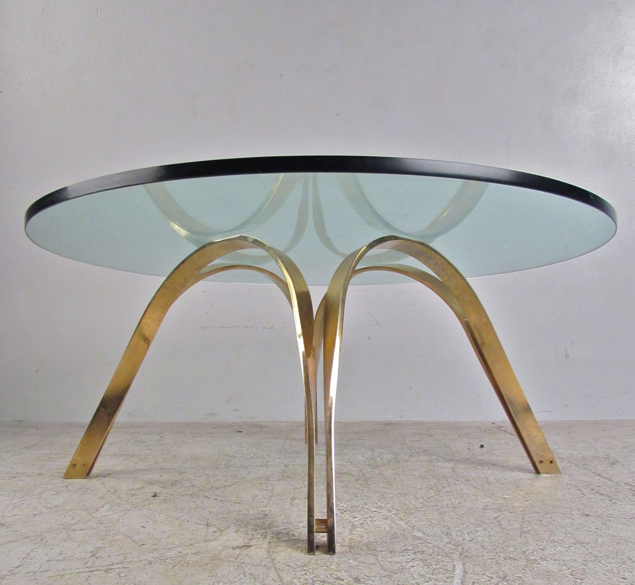 This unique 1960s coffee table features an elegant base that fits wonderfully with Mid-Century Modern decor. This Roger Sprunger design was originally crafted for Dunbar, and boasts a thick circular glass top, allowing it's clean and simple design