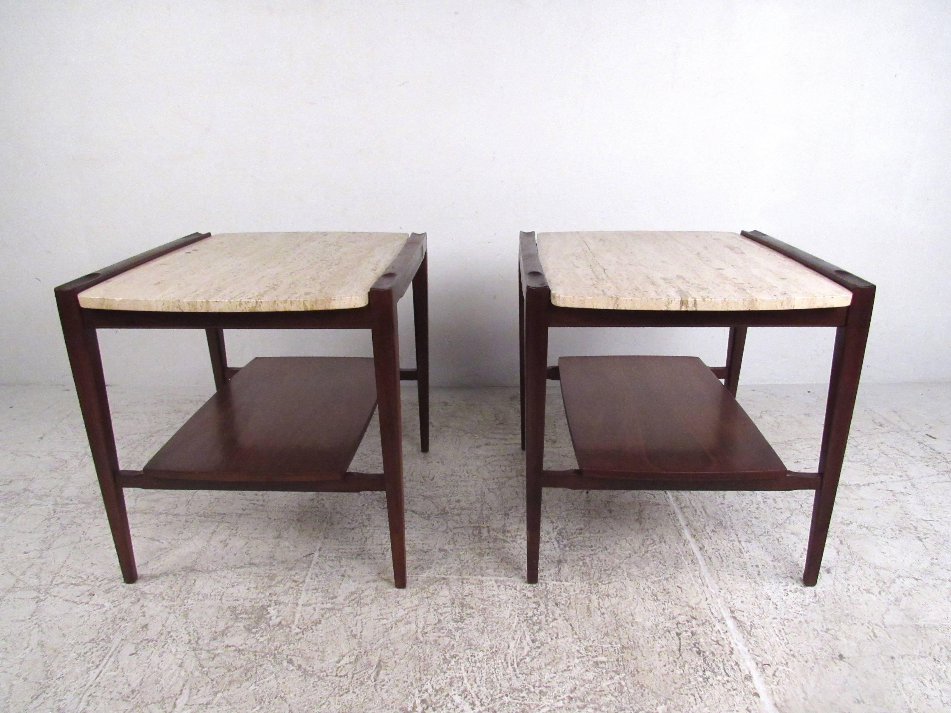 This stylish pair of Mid-Century end tables features unique two-tier design with tapered legs, white marble tops, and unique raised edge design. A dark vintage walnut finish and curved sides on the lower tier add to the allure. Wonderful vintage