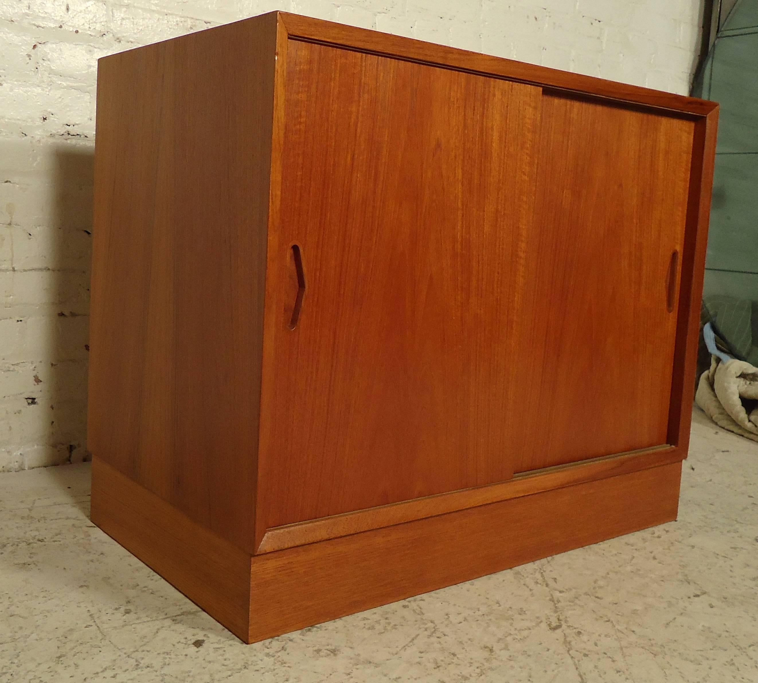 Beautiful vintage-modern cabinet features rich teakwood grain throughout.
Comes with one adjustable shelf and a set of sliding doors with sculpted handles.

(Please confirm item location - NY or NJ - with dealer).