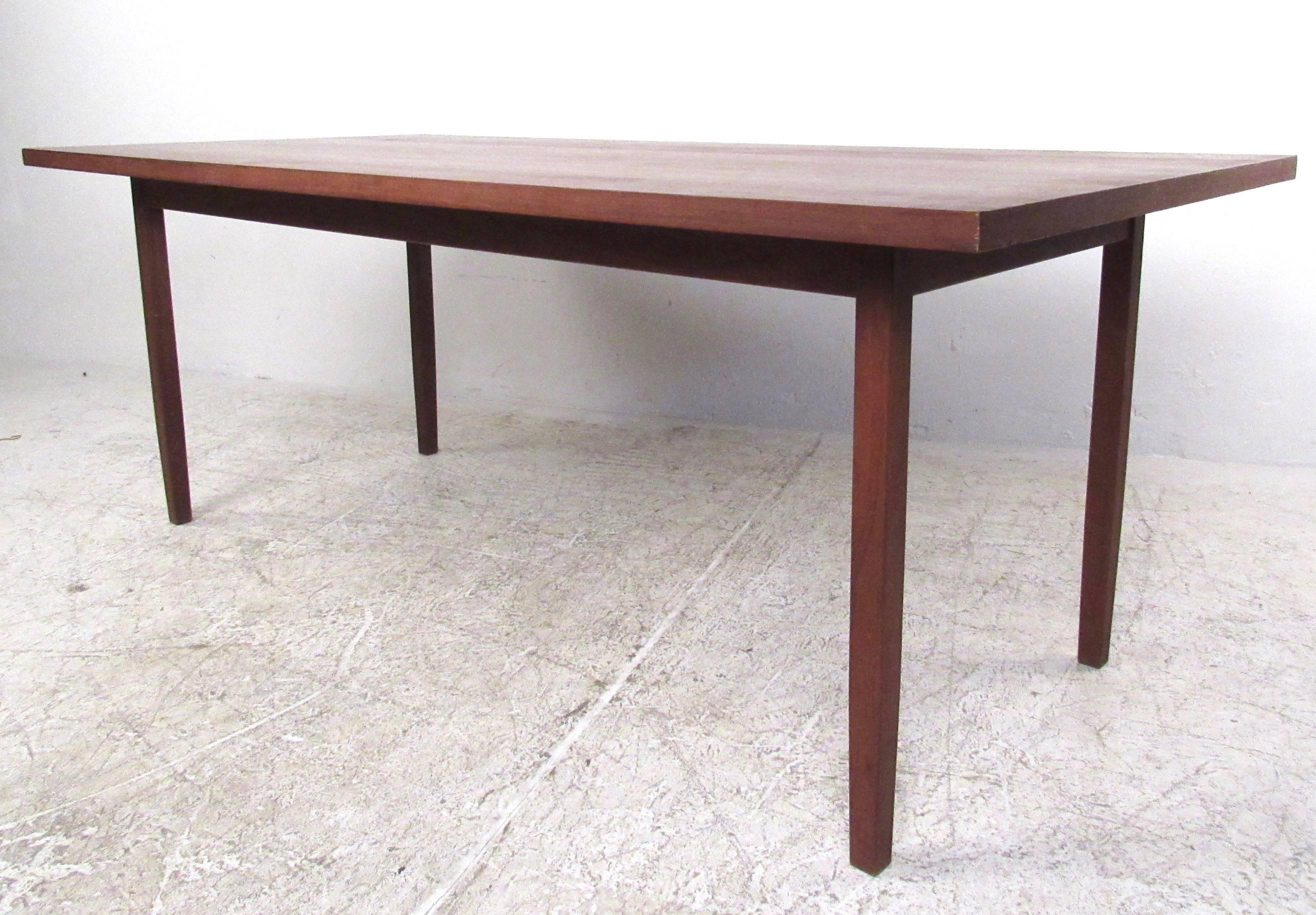 This unique Mid-Century Modern dining table by Knoll International features a vintage walnut finish, and a spacious tabletop perfect for large meals and hosting. Please confirm item location (NY or NJ).