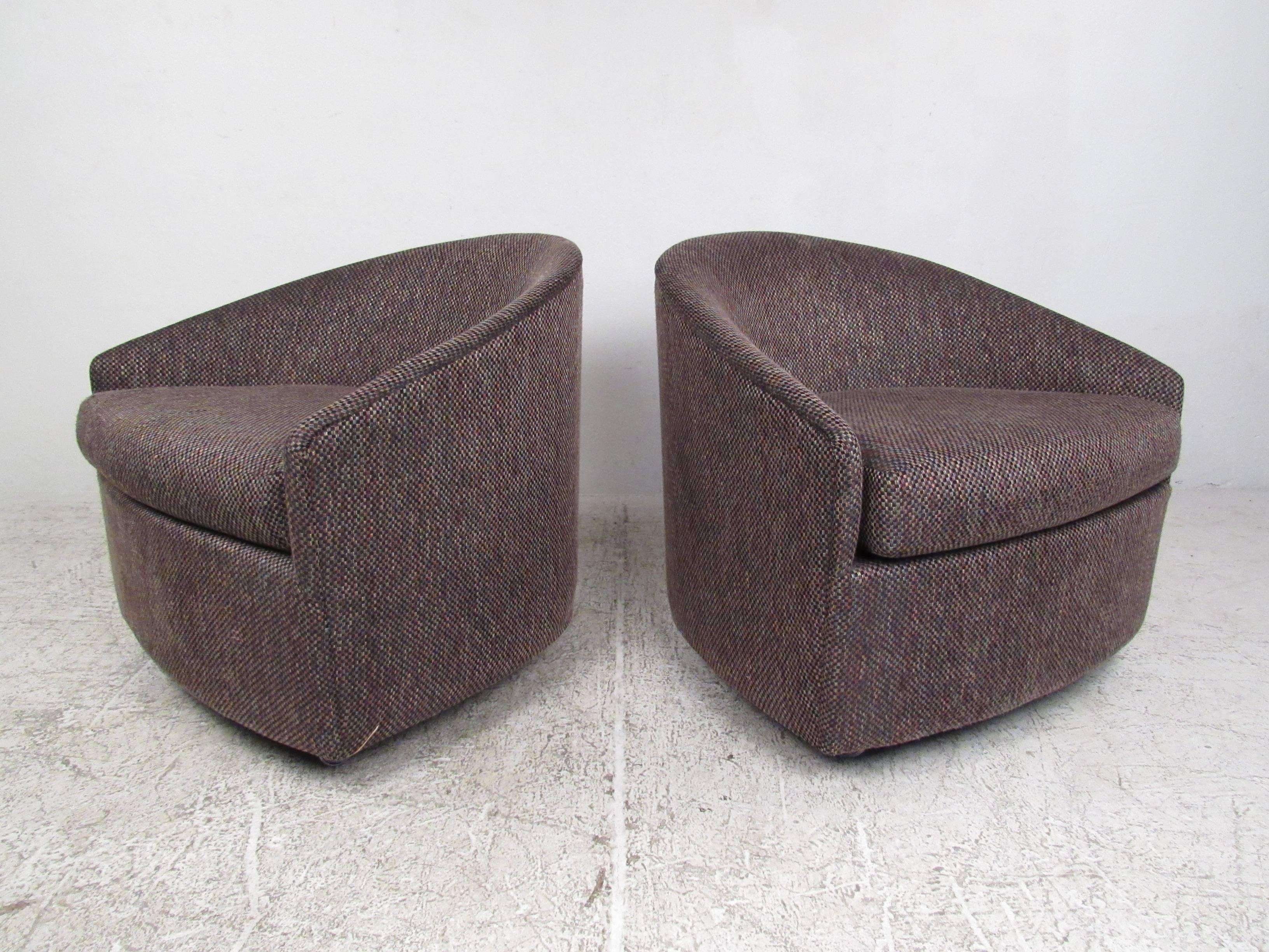 This unique pair of vintage lounge chairs features sculpted crescent shaped backs, stylish vintage fabric and comfortable design. Rolling casters make these an excellent option for occasional seating in any modern interior. Please confirm item