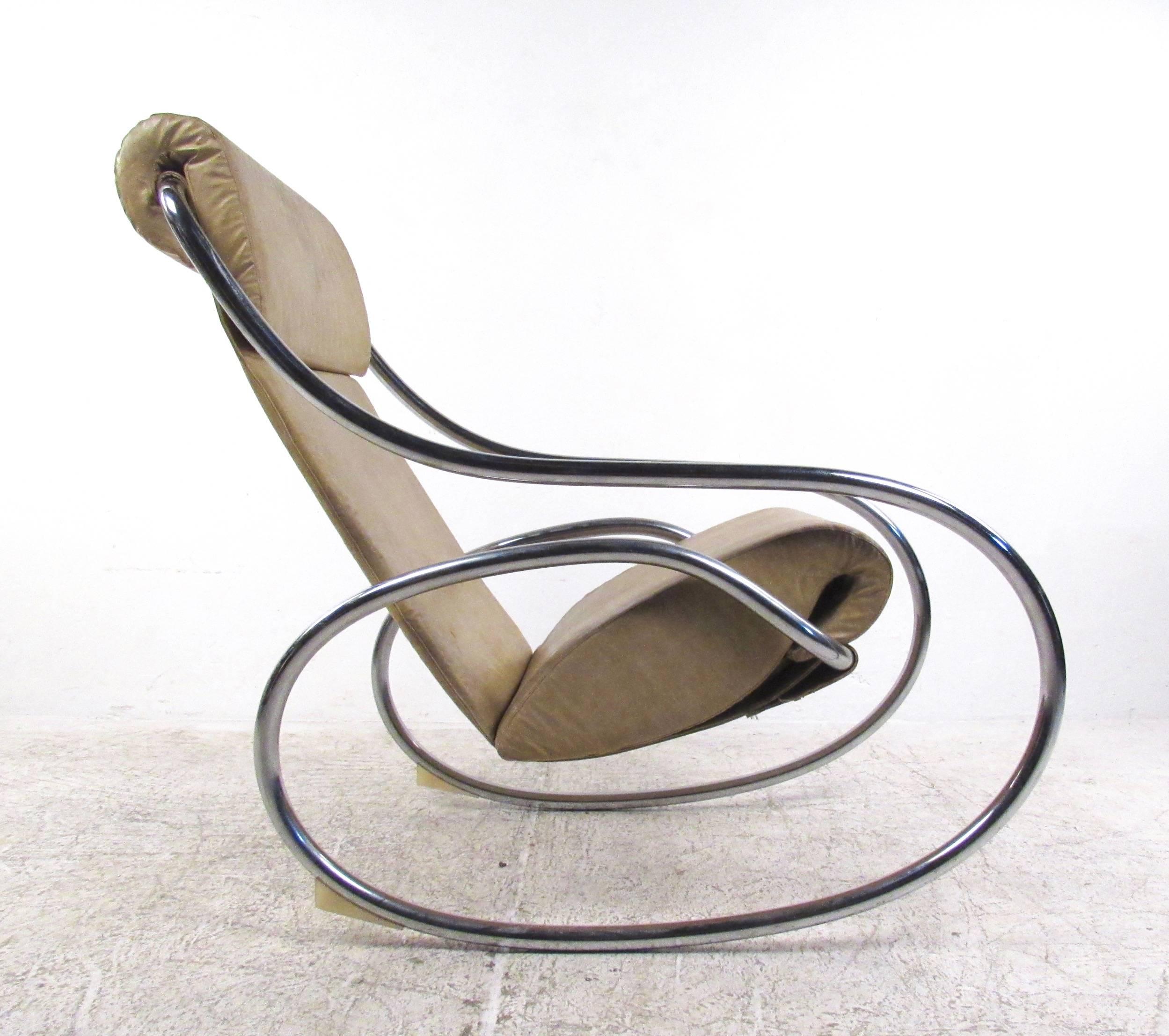 Ce rocking-chair vintage en métal et vinyle présente un cadre chromé élégant avec des bascules circulaires uniques. Le revêtement en vinyle vintage est sculpté pour un confort ergonomique, ce qui en fait un fauteuil à bascule d'appoint idéal dans