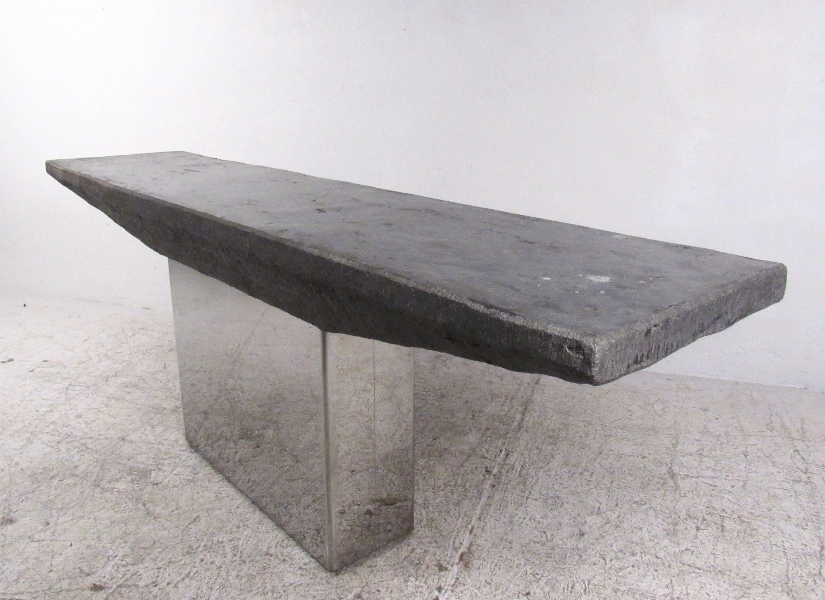 This unique decorator's table features an impressive angled slate style composite top. Mounted on a sturdy polished steel base, this console table strikes an unusual shape and is the perfect size for entryway, hall or sofa use. Ideal display table