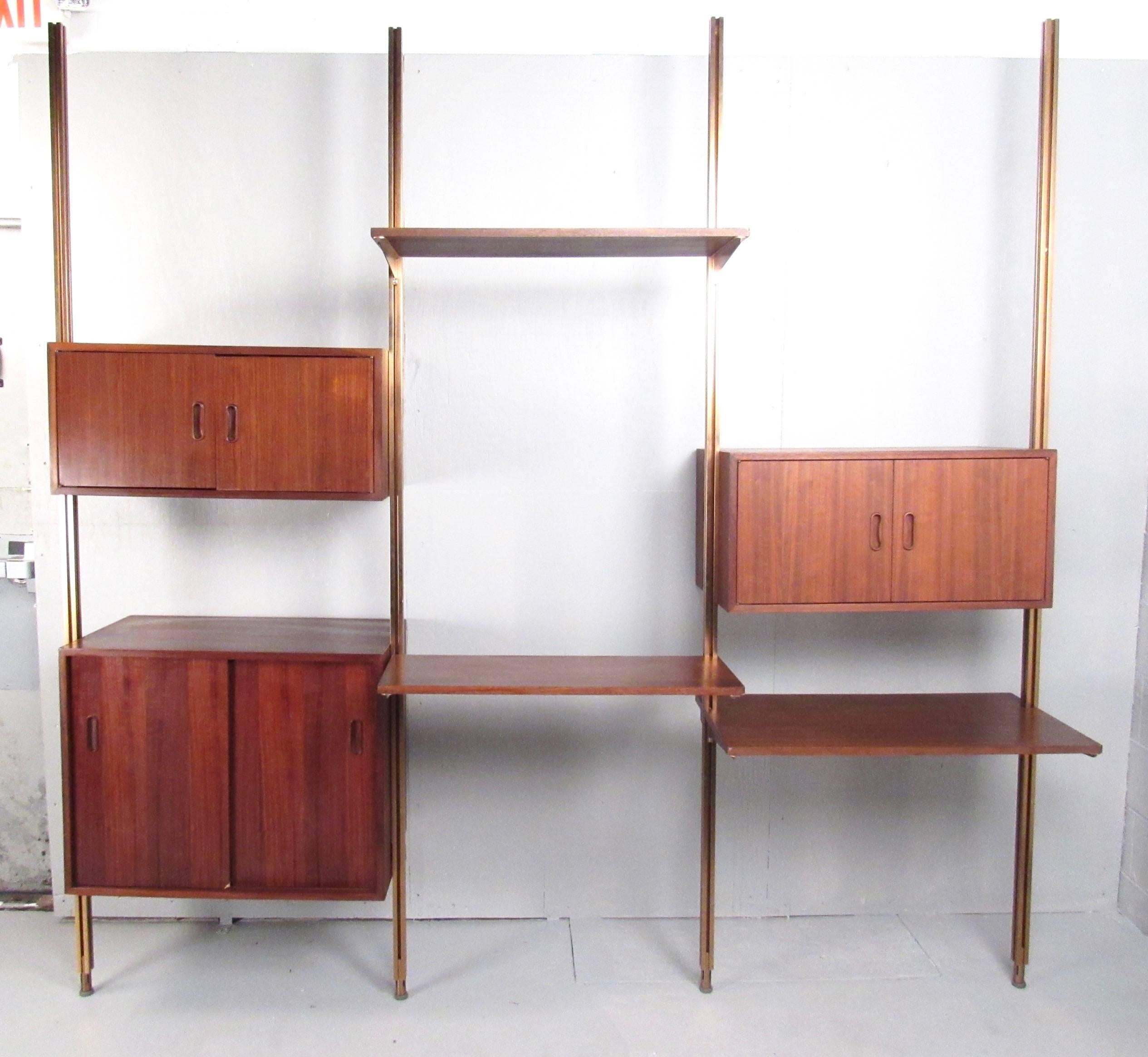 This beautiful vintage teak wall unit features modular cabinets and shelves mounted to custom metal floor supports. The orientation of the wall unit can be customized to your specifications, but unit's must be mounted to the wall as well. Carved