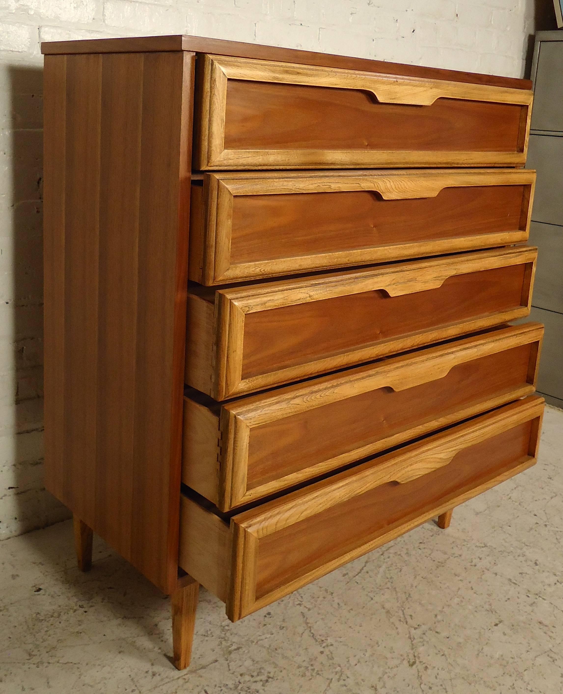 This vintage modern high boy by Bassett furniture features rich walnut grain with accenting oak trim. Five wide drawers, beautifully sculpted handles, on a set of sturdy legs.

Please confirm item location (NY or NJ) with dealer.

