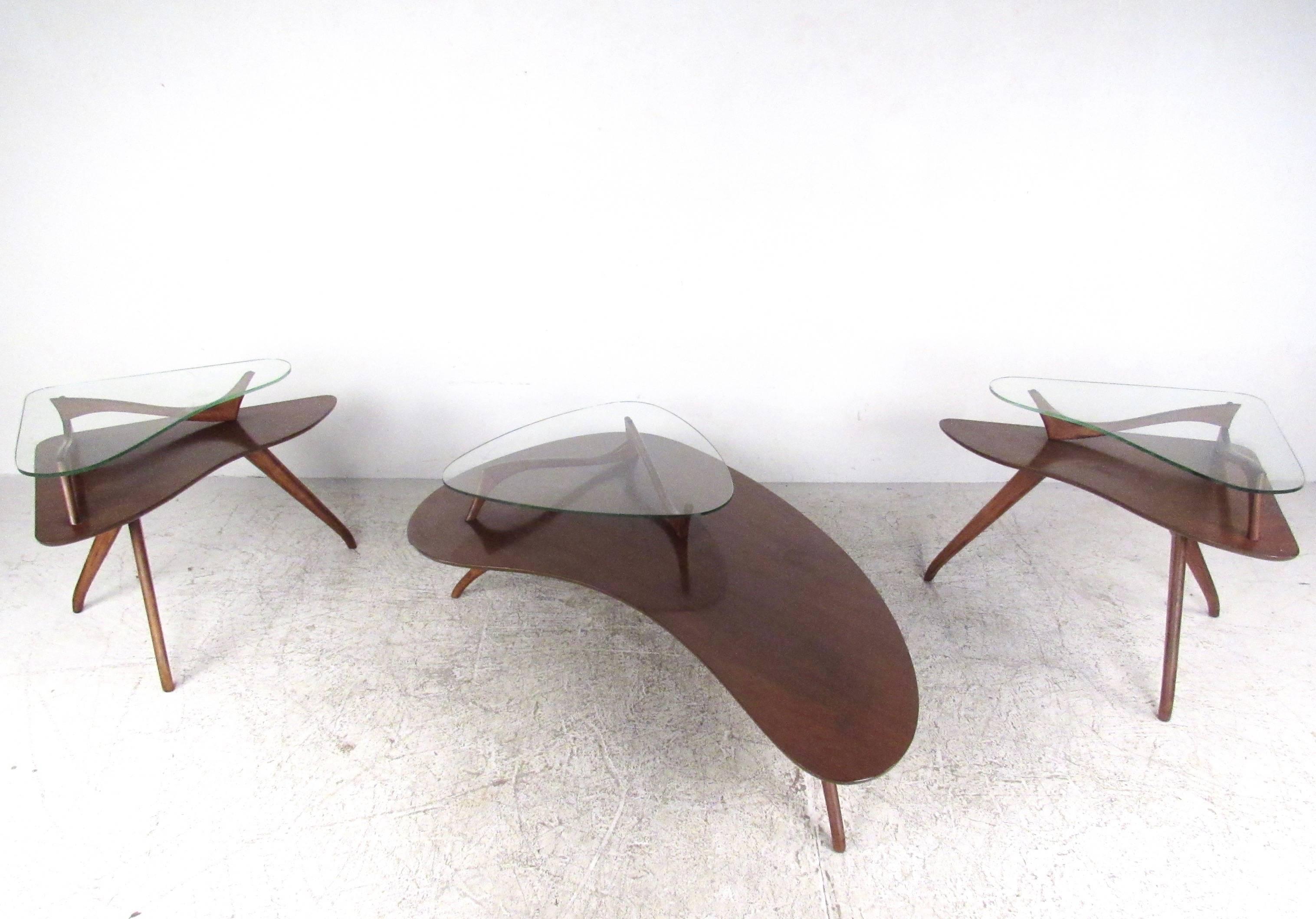 This stunning set of three sculptural tables features the unique design style of Mid-Century master Vladimir Kagan. Uniquely tapered legs, biomorphic style tops, and unique second tier glass tops set this stylish set of tables apart from other