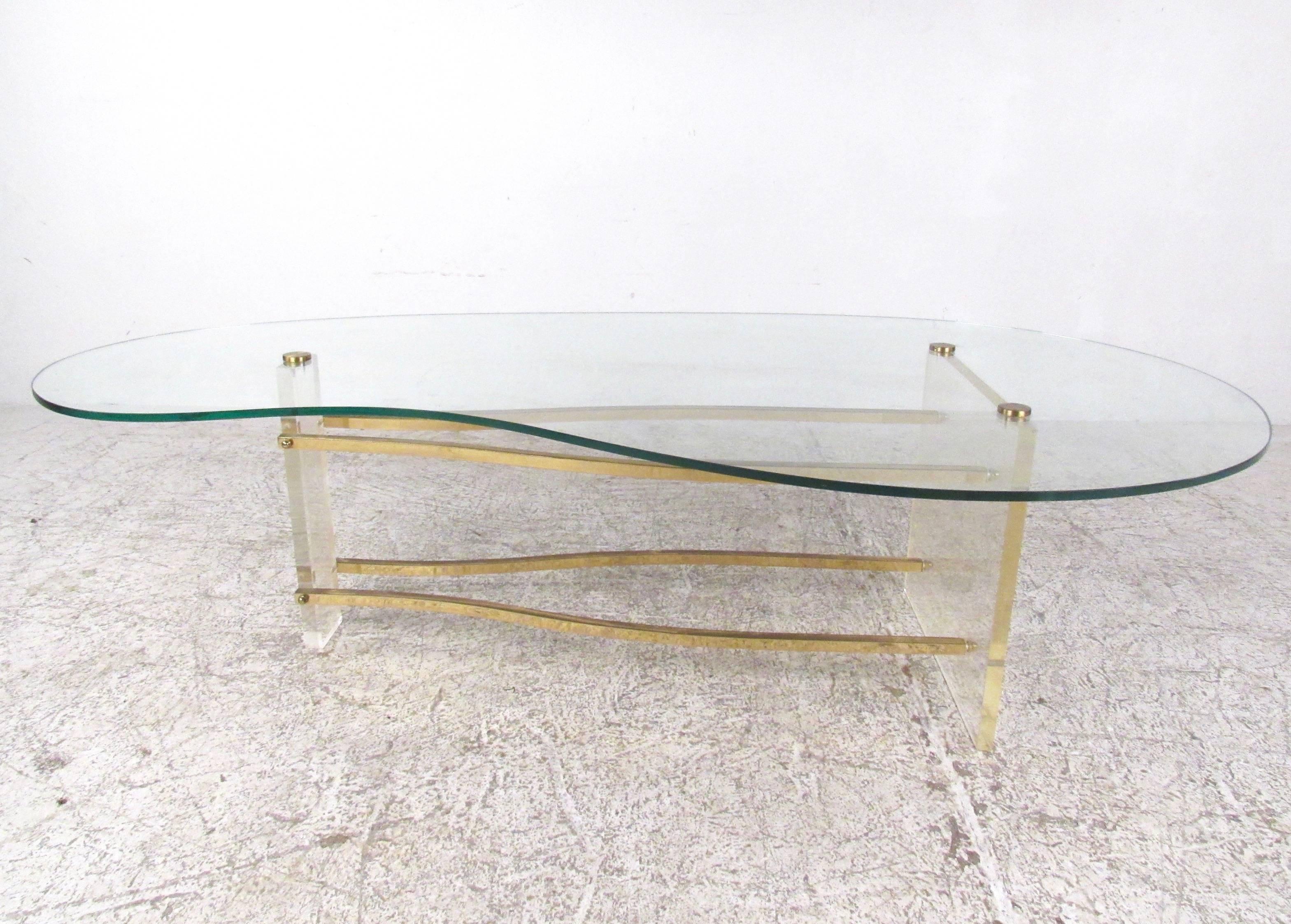 This stunning vintage coffee table features a kidney shaped glass top mounted on a brass and Lucite base. This Charles Hollis Jones design features unique Mid-Century Modern style and makes an elegant addition to any home or office. Please confirm