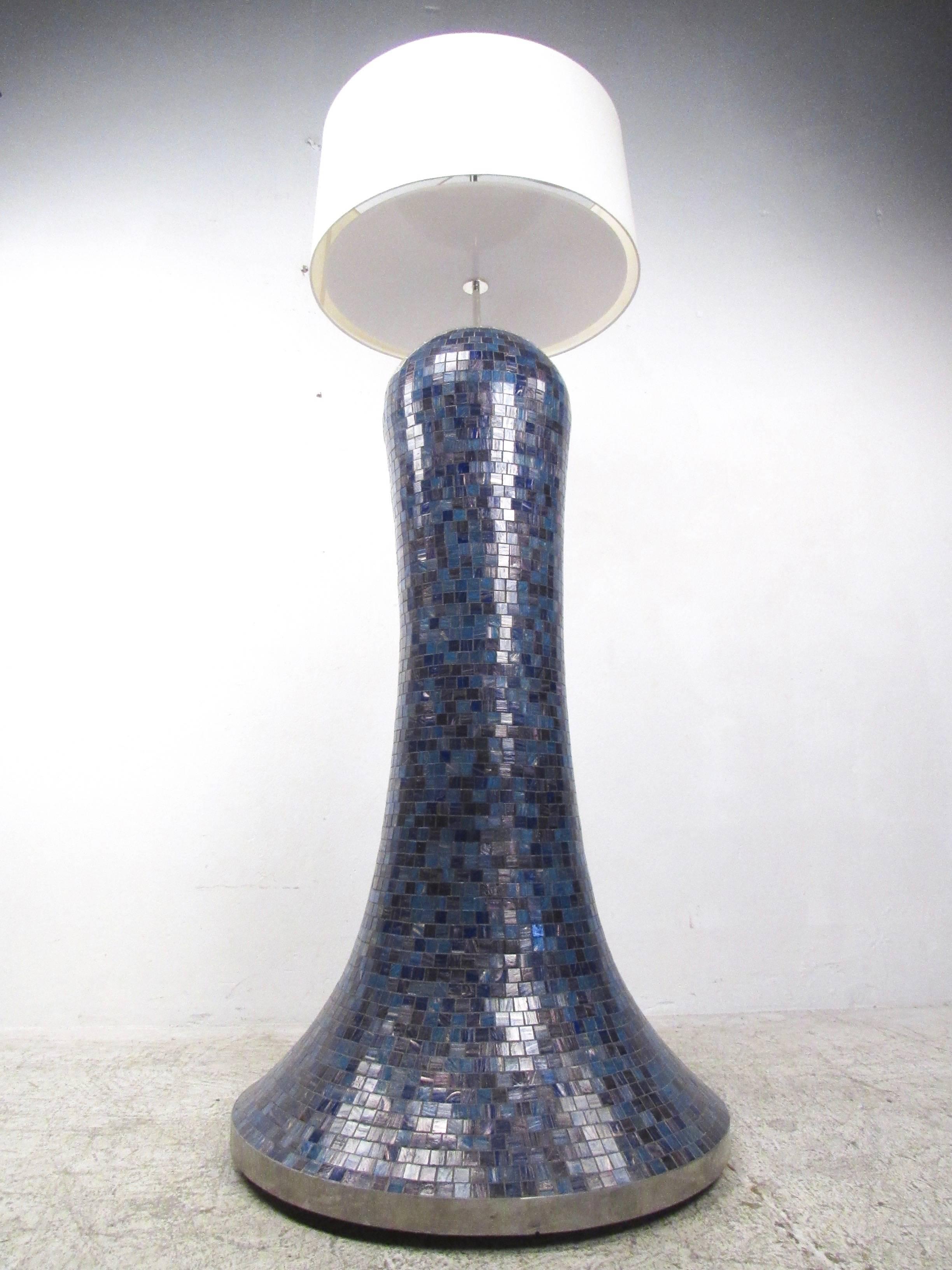 This impressive studio made floor lamp features a stunning oversized design with rounded top and flared base. Chrome trim and fixtures offer a unique contrast to the shades of blue and purple found throughout the mosaic tile finish. Unique silver