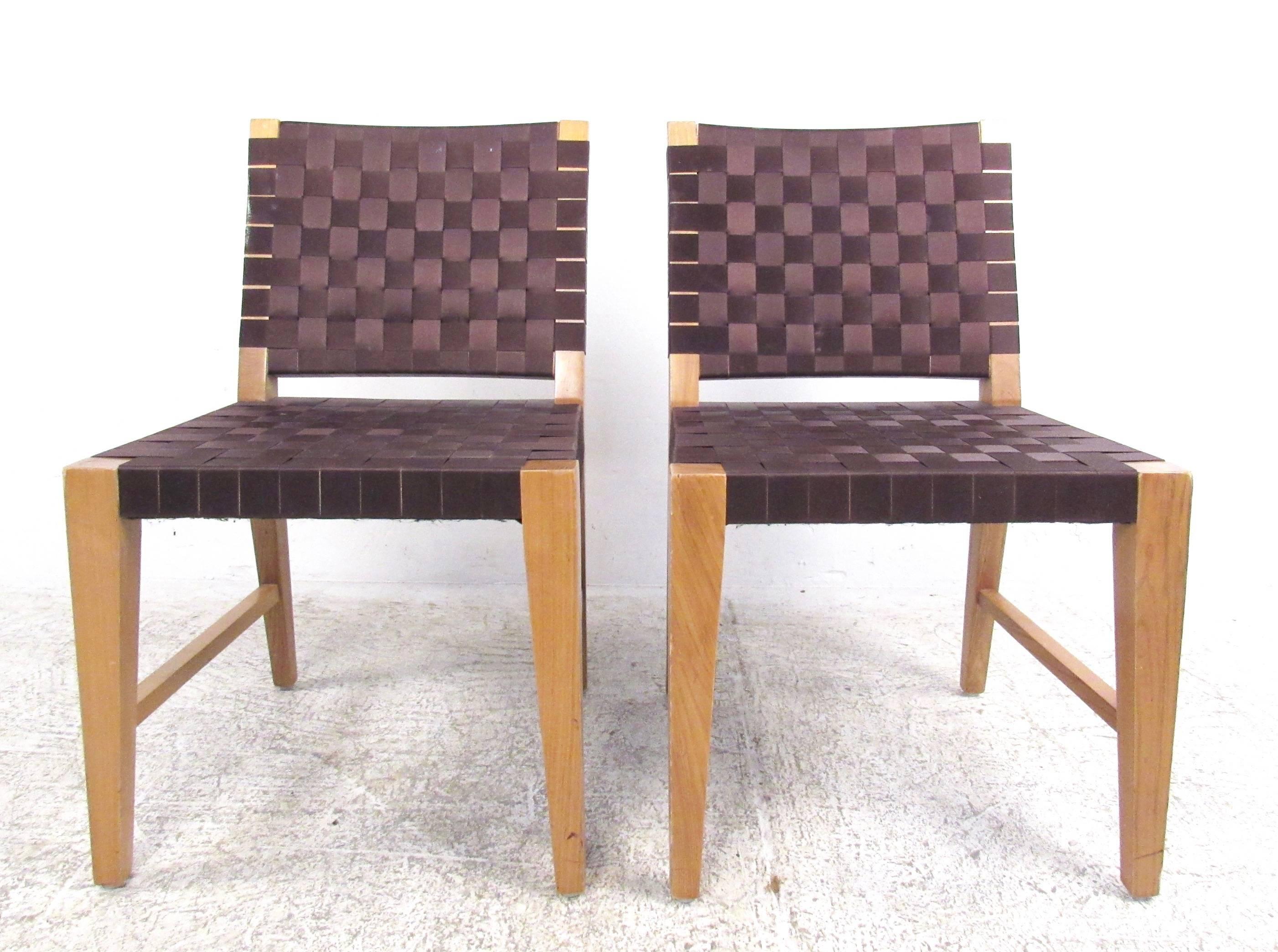 This set of four contemporary side chairs feature the Mid-Century Modern design style of Jens Risom, incorporating woven nylon straps over sturdy hardwood frames. Uniquely angled and tapered legs feature side stretchers for added stability and