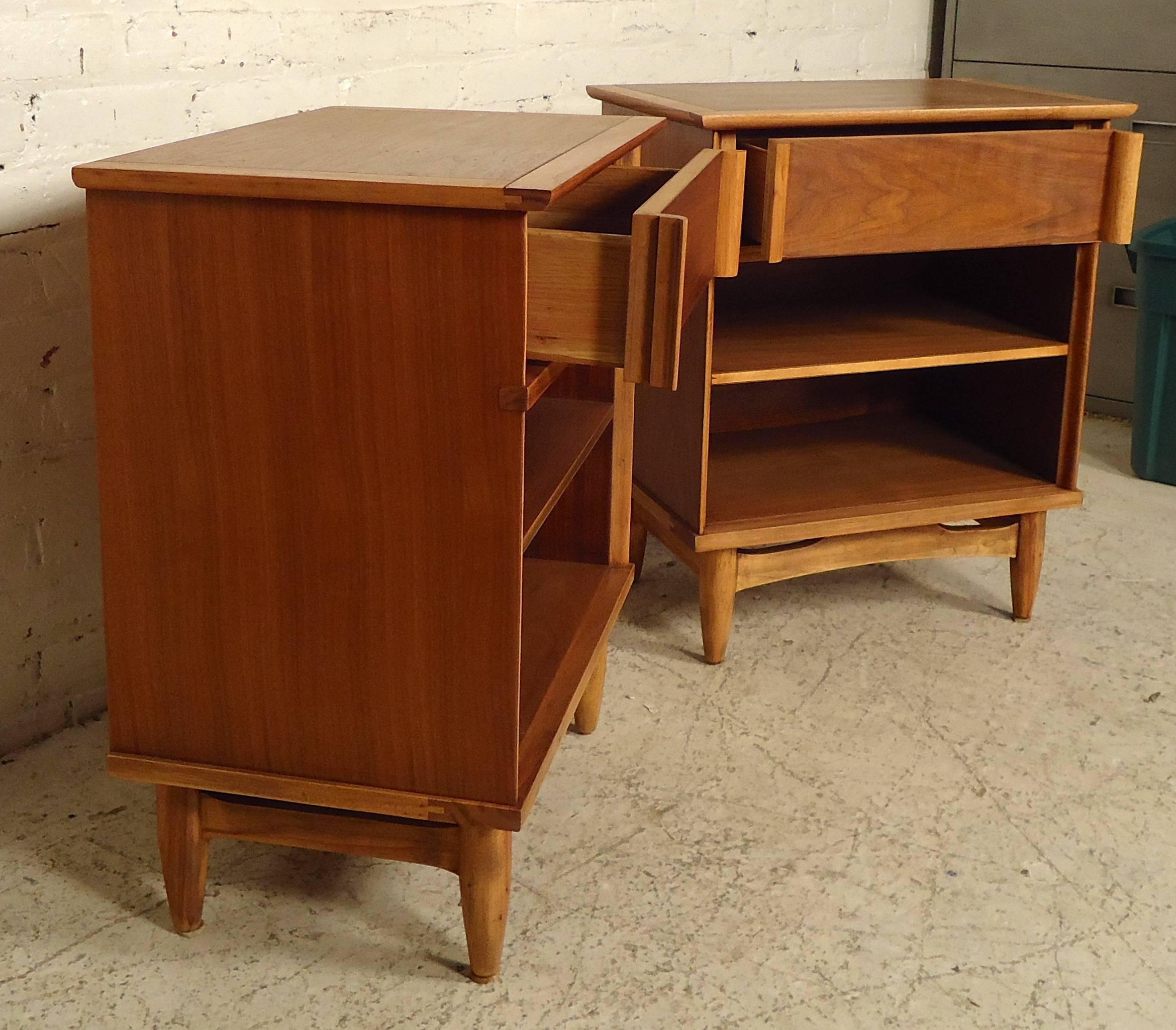 Great pair of vintage modern side tables featuring rich walnut grain wood, one drawer with elegantly carved side handles, and two lower storage compartments. Lovely accenting oak and walnut grain.

(Please confirm item location - NY or NJ with