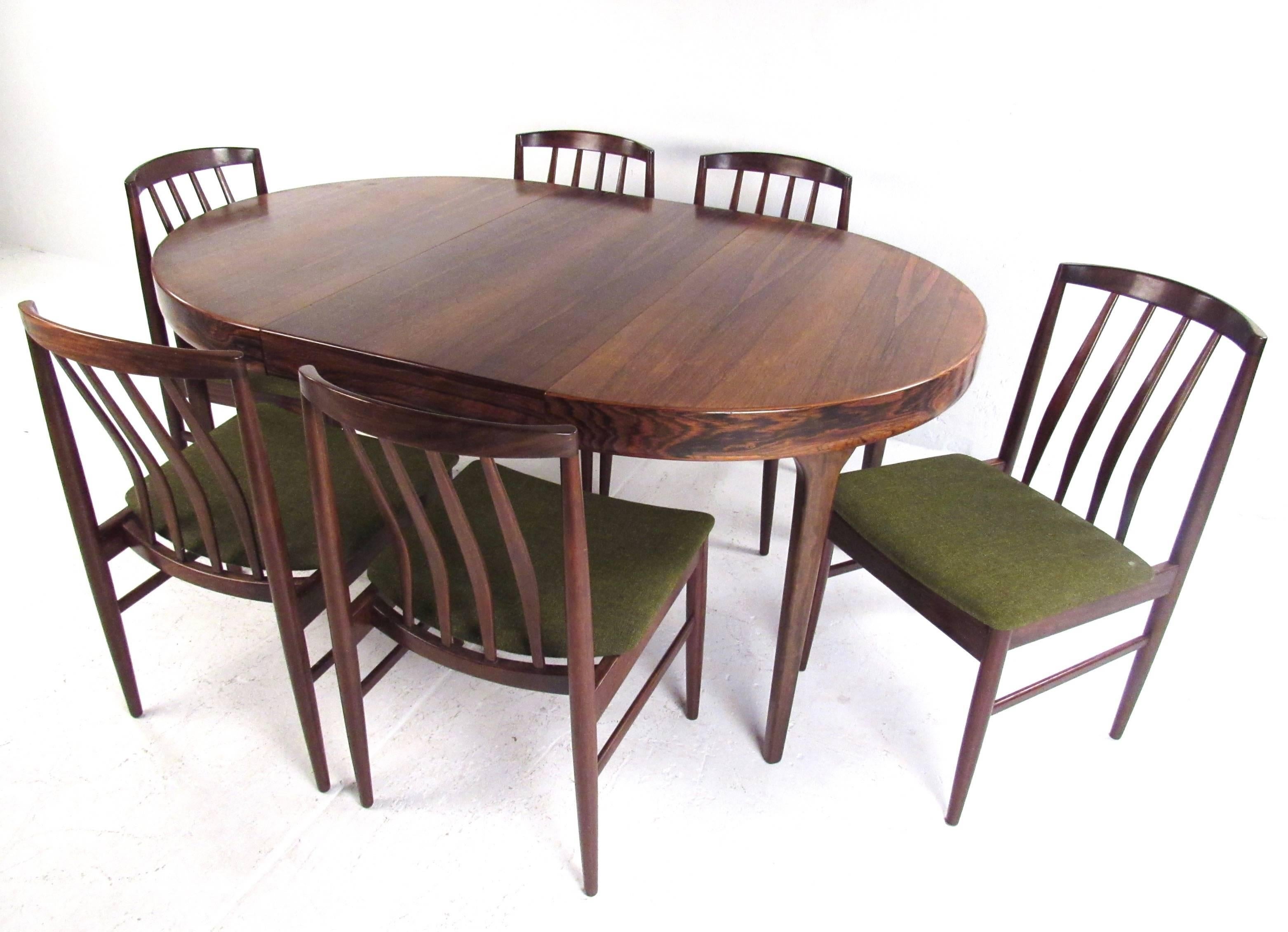 This stunning vintage Danish dining set features six sculpted rosewood chairs by Vamo Sonderborg and circular Ib Kofod-Larsen dining table. Table opens up from 43.5 inches in diameter to 102.75 inches wide with three leaves installed. The stunning