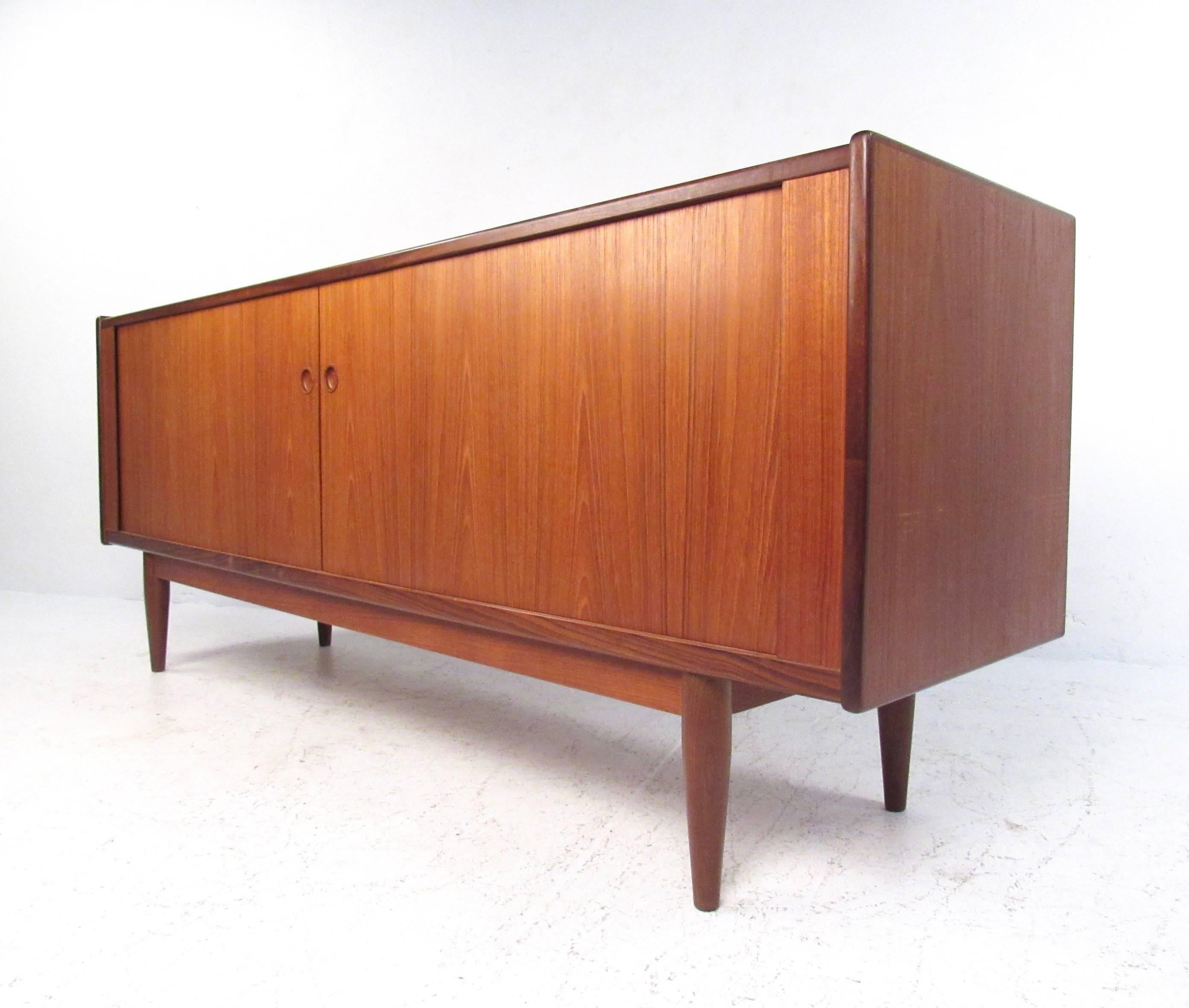 This vintage teak sideboard features a tambour design similar to that of Hans Wegner's 