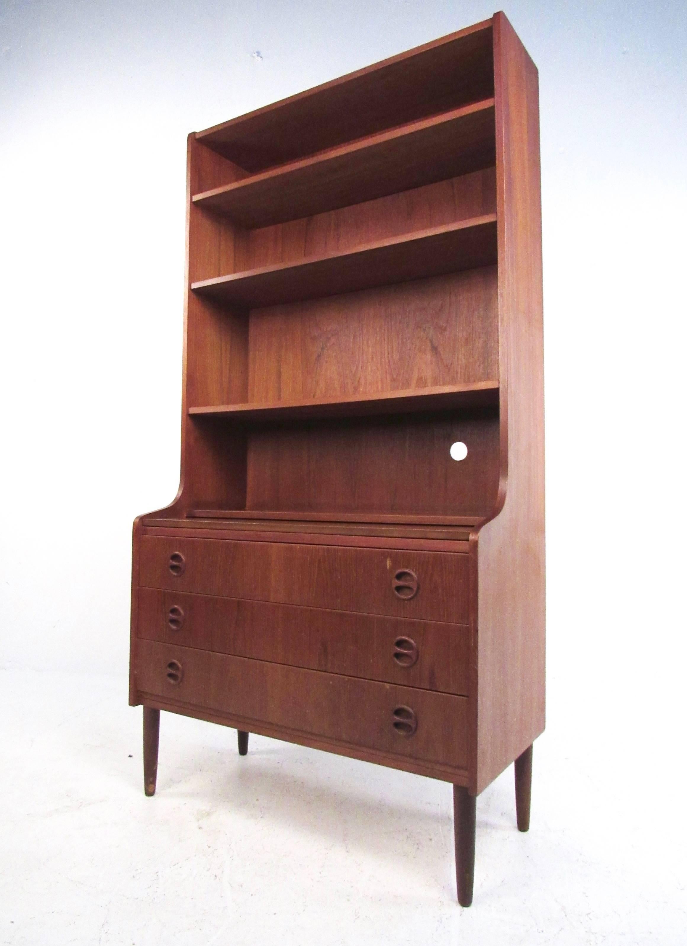 This vintage modern Danish teak shelf unit features stylish Mid-Century construction, plenty of shelf space for display, and a three-drawer cabinet for storage. Additional pull-out work space makes this a great occasional desk for a variety of