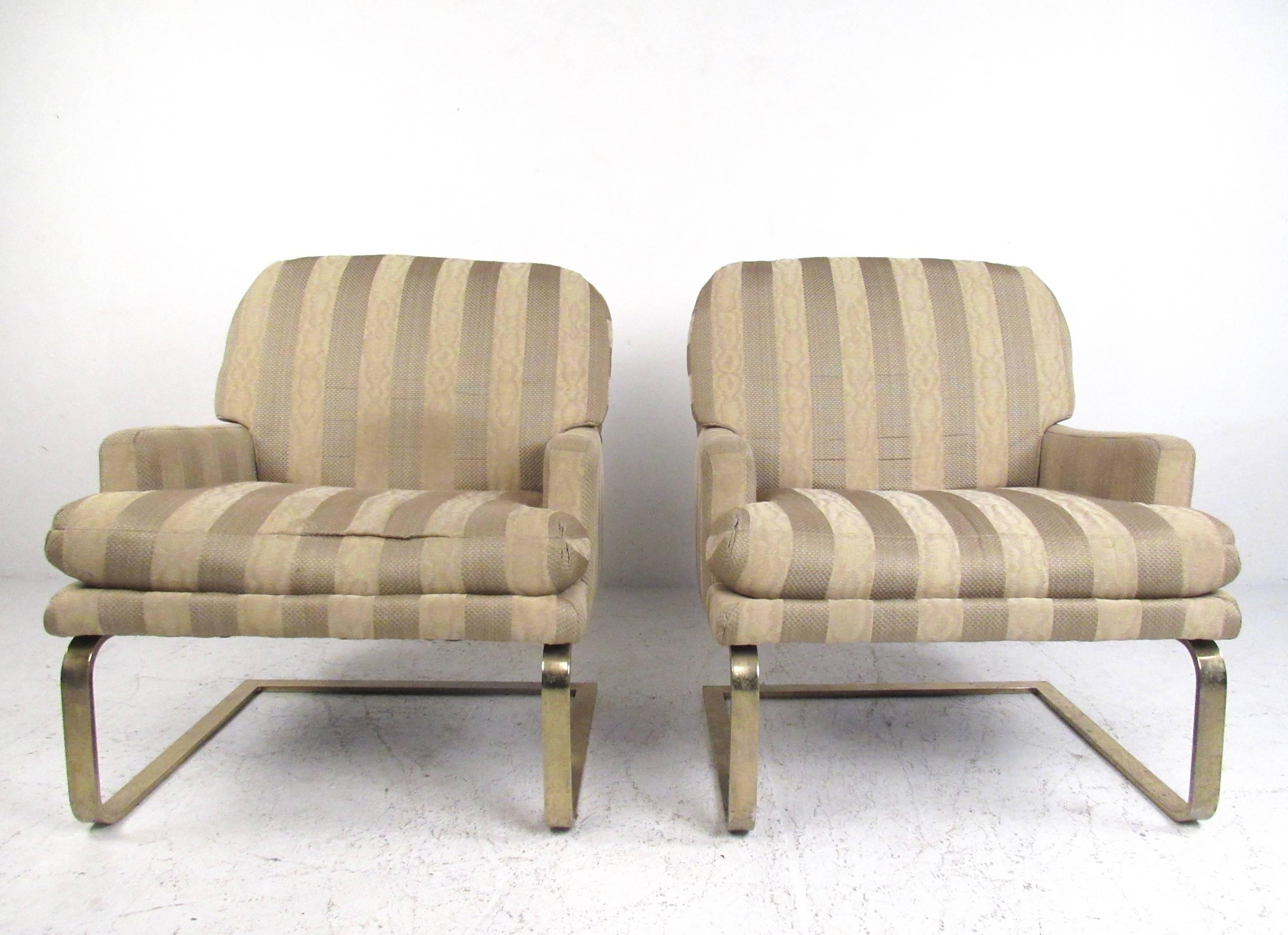 This vintage pair of Selig armchairs features comfortable upholstered seats with plus cushioning and stylish cantilever base. Brass finish metal legs compliment the Mid-Century style of the striped fabric. Manufactured by American furniture maker