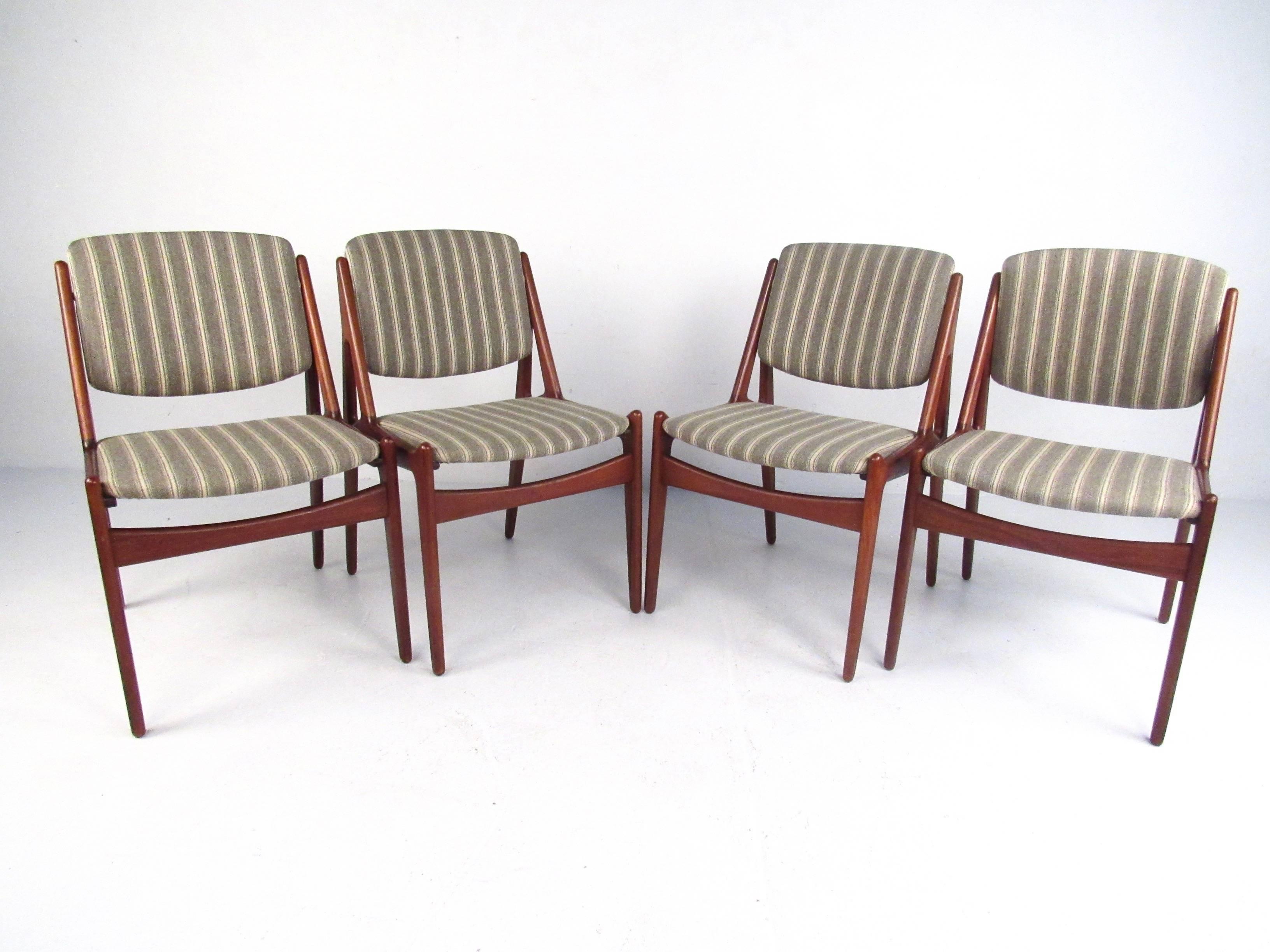 This stunning set of Danish modern dining chairs features sculpted teak frames, with pivoting backs and paired with striped vintage fabric. Designed by Mid-Century great Arne Vodder for Vamo Møbelfabrik, this exquisite matching set of four makes an