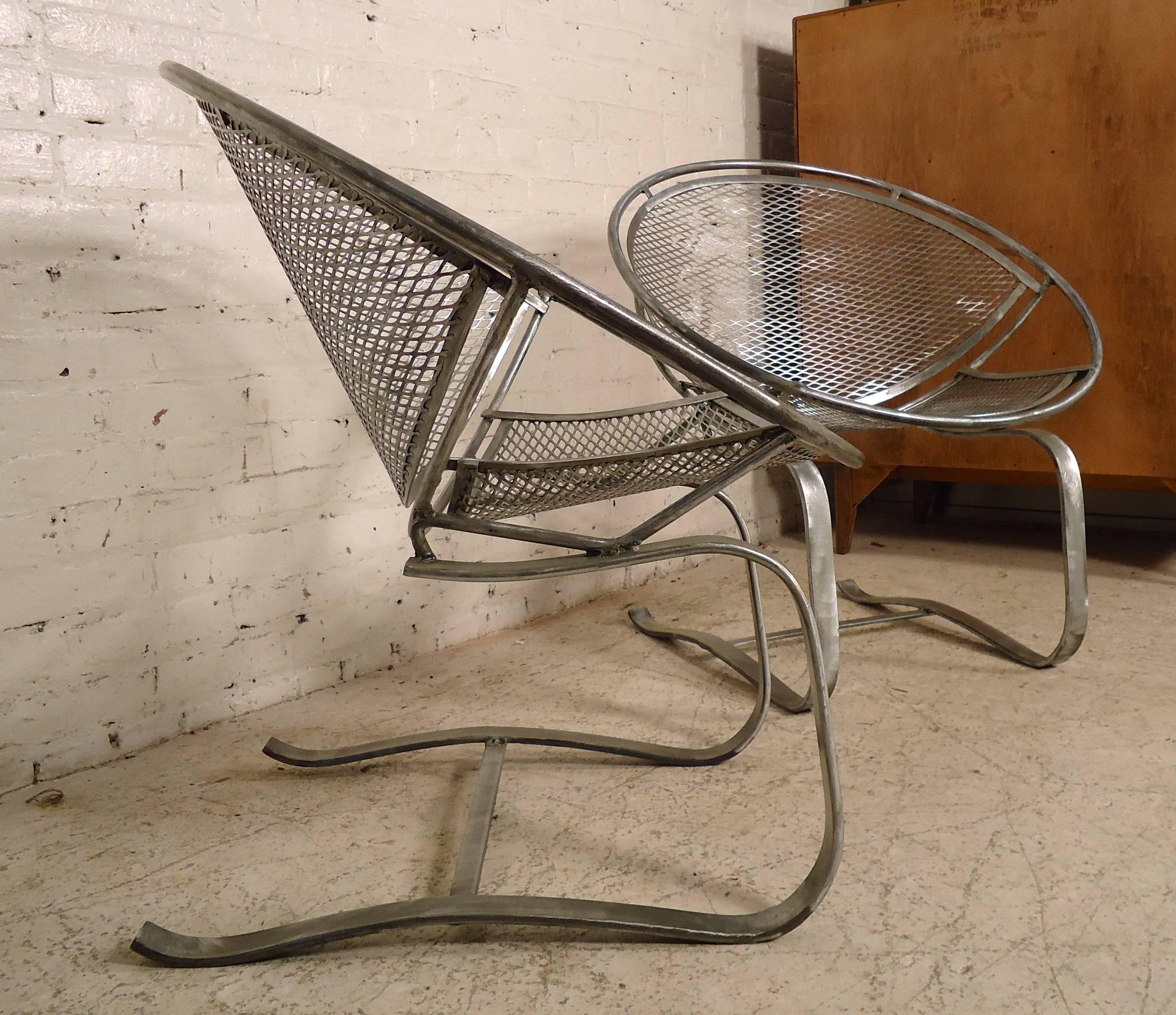 Pair of unique spring chairs by Salterini in strong wrought iron. Spring action, round saucer like frame, with mesh metal backing. These chairs have been completely stripped, grinded, and polished. Great for home or patio use.

(Please confirm