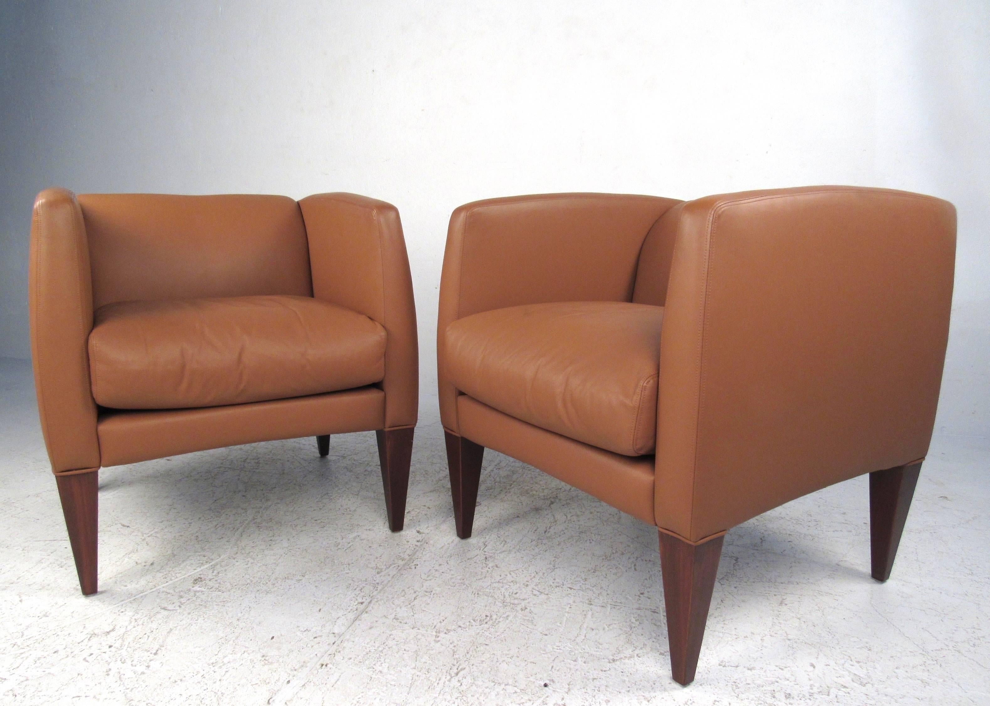 This stylish and comfortable pair of contemporary modern lounge chairs feature supple spinney beck Italian leather, tapered hardwood legs, and comfortable padded seat back. Matching pair is ideal for home or business use, and make a stylish yet