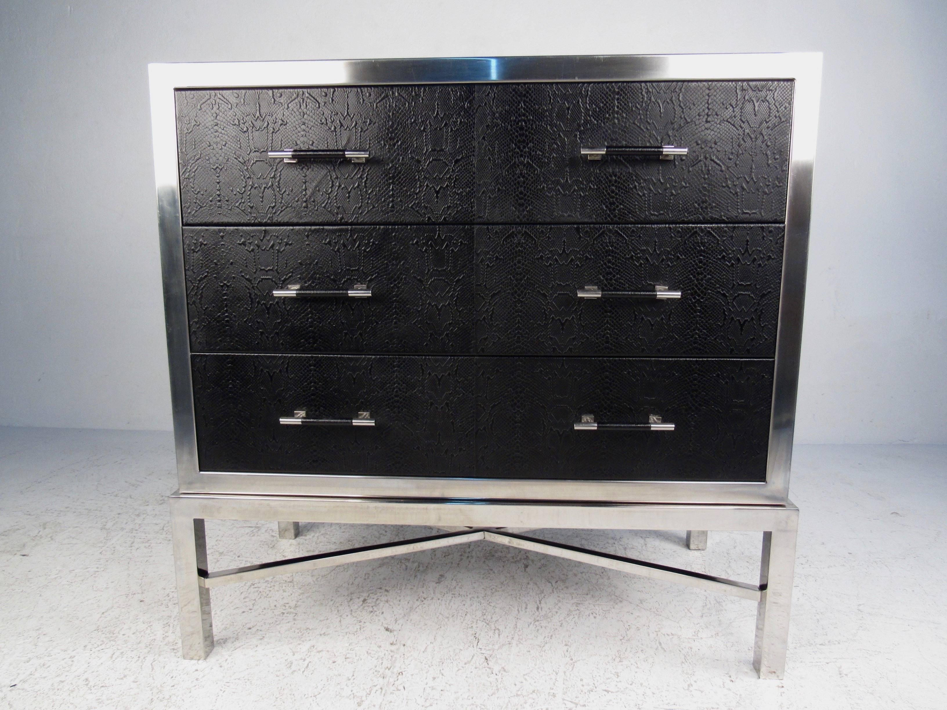 This impressive contemporary modern chest of drawers features a heavy chrome frame with faux snakeskin finish. Fabric lined drawers, X style stretchers, and unique pulls make this spacious storage piece a practical and stylish addition to any