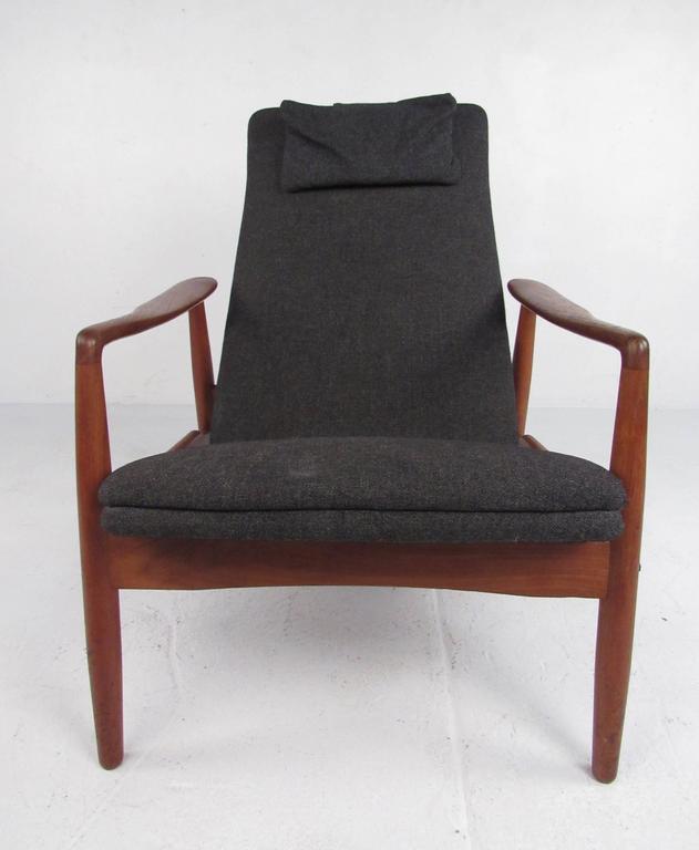 This vintage teak frame lounge chair features Scandinavian modern design by SL Mobler, circa 1950s in the style of Ib Kofod-Larsen. Sculpted armrests, sculpted high back seat, and comfortable design add to the Mid-Century appeal of the piece.