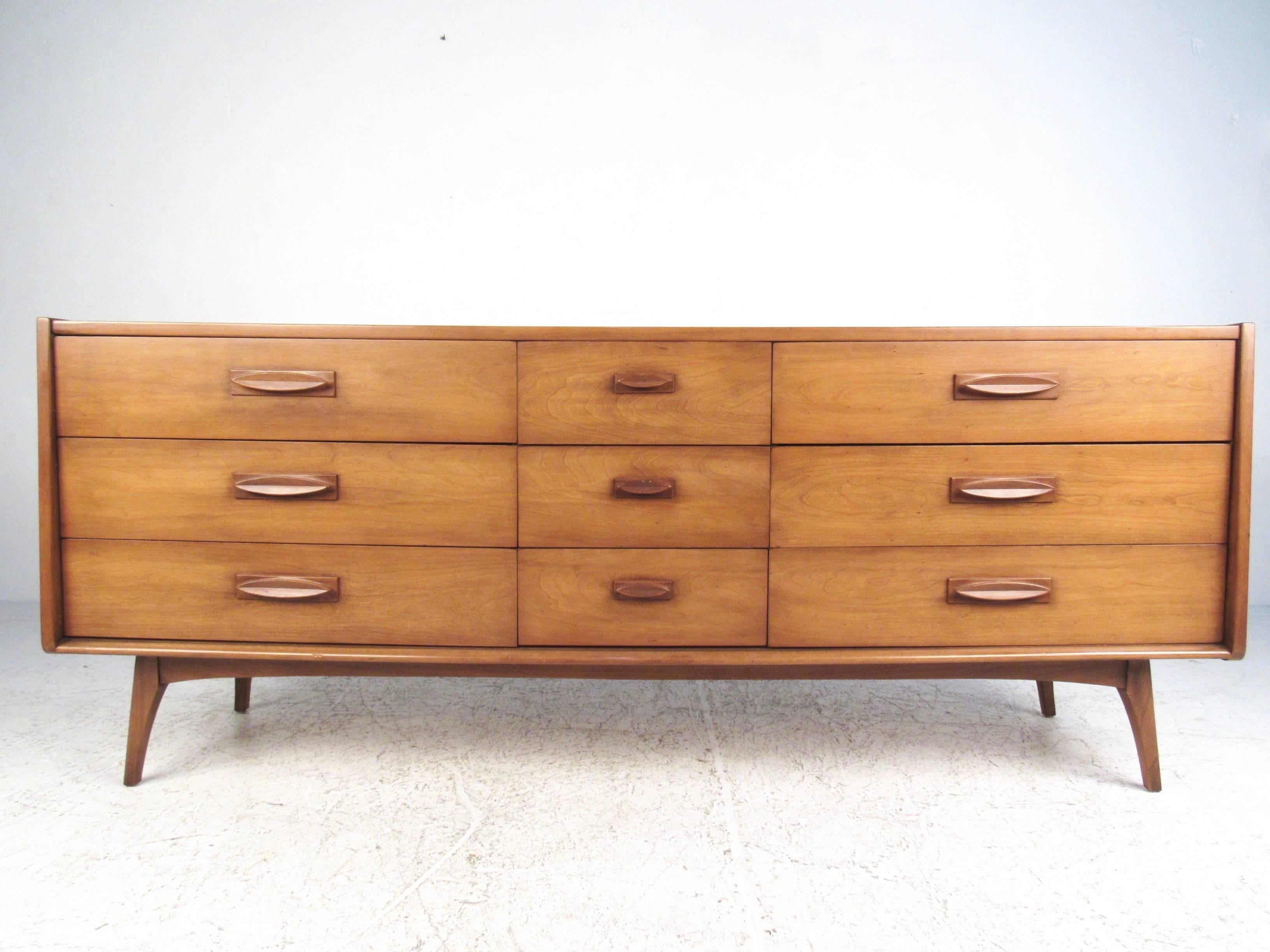 This beautiful pair of Mid-Century Modern storage dressers comes complete with matching two-drawer nightstand. Wonderful matching drawer pulls for all three pieces are the perfect addition to the simple, modern lines of the set. Plenty of stylish