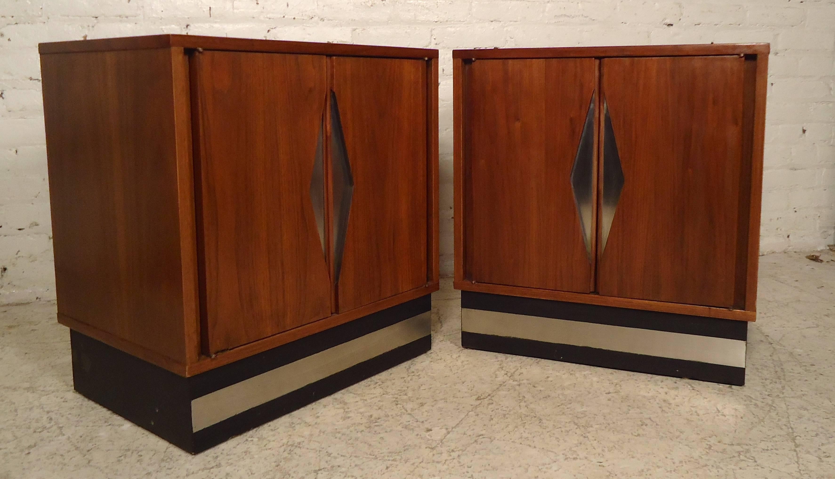 This unique pair of vintage-modern nightstands features a chrome diamond front design sculpted in the center of two doors. Made of rich walnut grain and sits on a sturdy black base, each contains one shelf. 

Please confirm item location (NY or