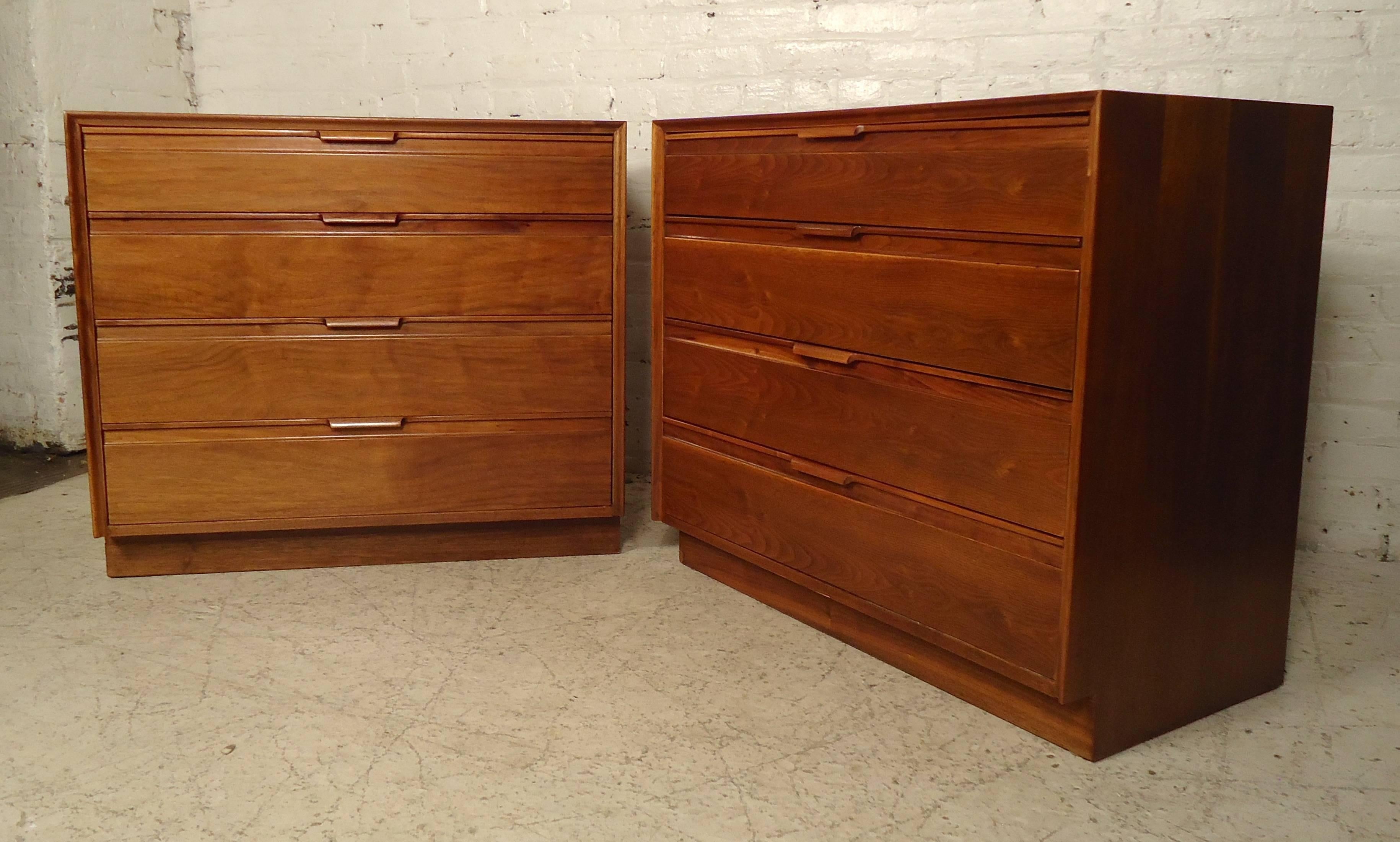 Vintage-modern pair of short dressers by American of Martinsville. Made of rich walnut grain features four wide drawers with sculpted handles on a sturdy base.

Please confirm item location (NY or NJ.)
