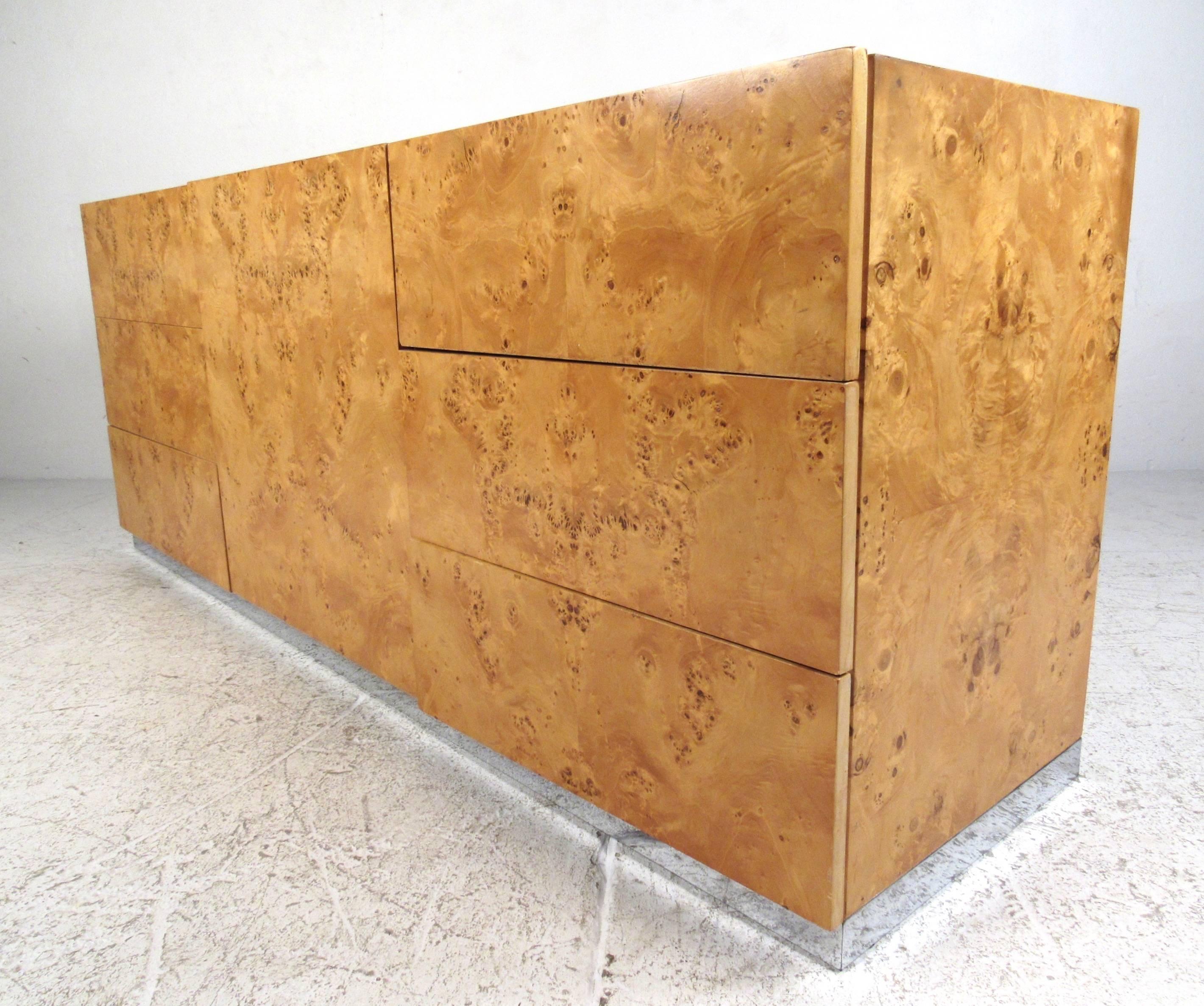 This vintage modern server features a beautiful burl wood finish with complimentary chrome trim. Simple clean lines are accented by the stunning golden finish, while spacious drawer and cabinet storage make this a useful addition to any interior.