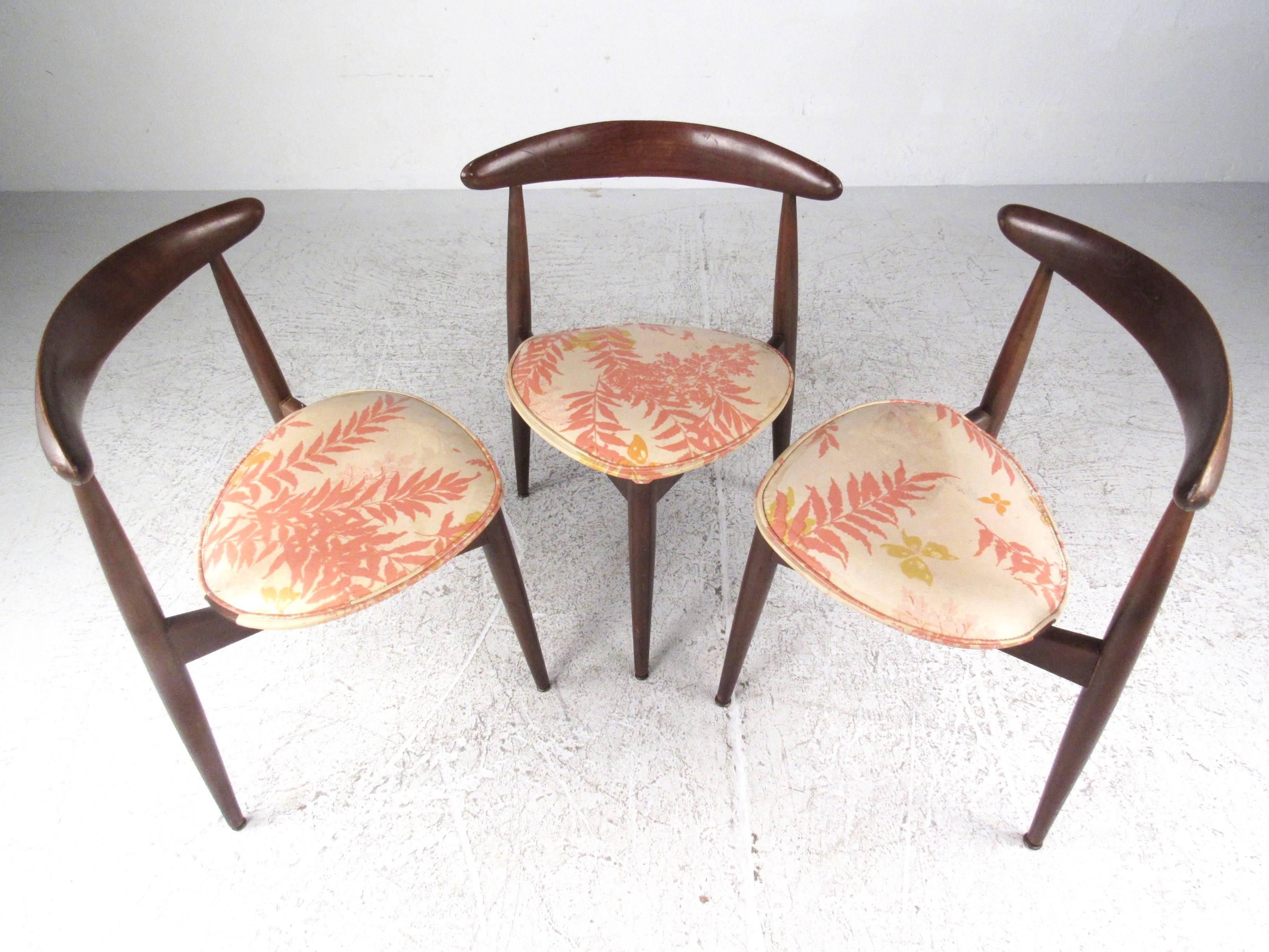 This set of vintage chairs features three leg design by Hans Wegner, with unique heart shaped seats, sculpted legs and seat back, and stunning Mid-Century Modern style. These iconic chairs still bare the original manufacturer's markings, model