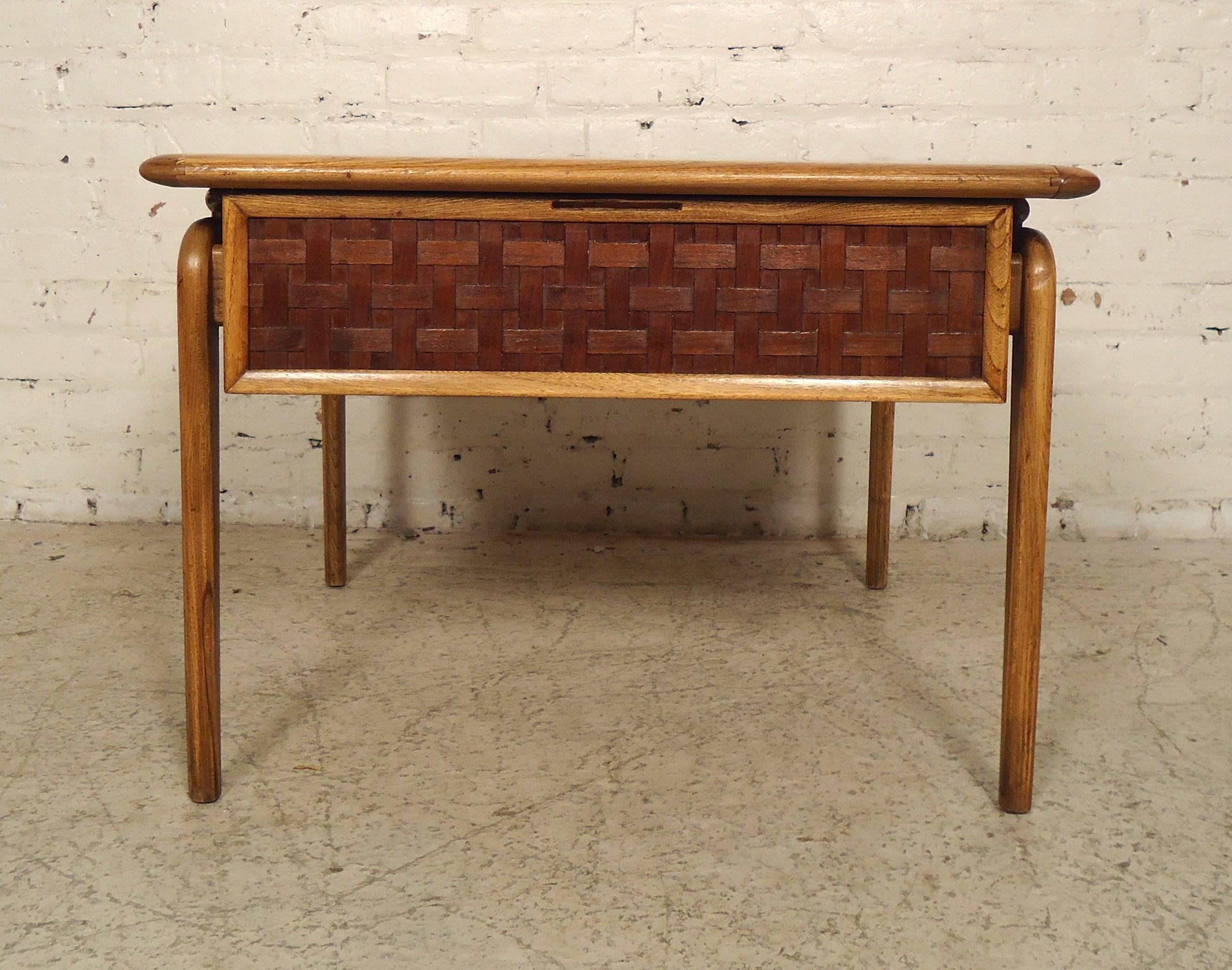 Unique vintage-modern style end table designed by Lane. Features flowing lines, made of walnut, standing on sturdy side legs with basket weave drawer.

(Please confirm item location - NY or NJ - with dealer).
