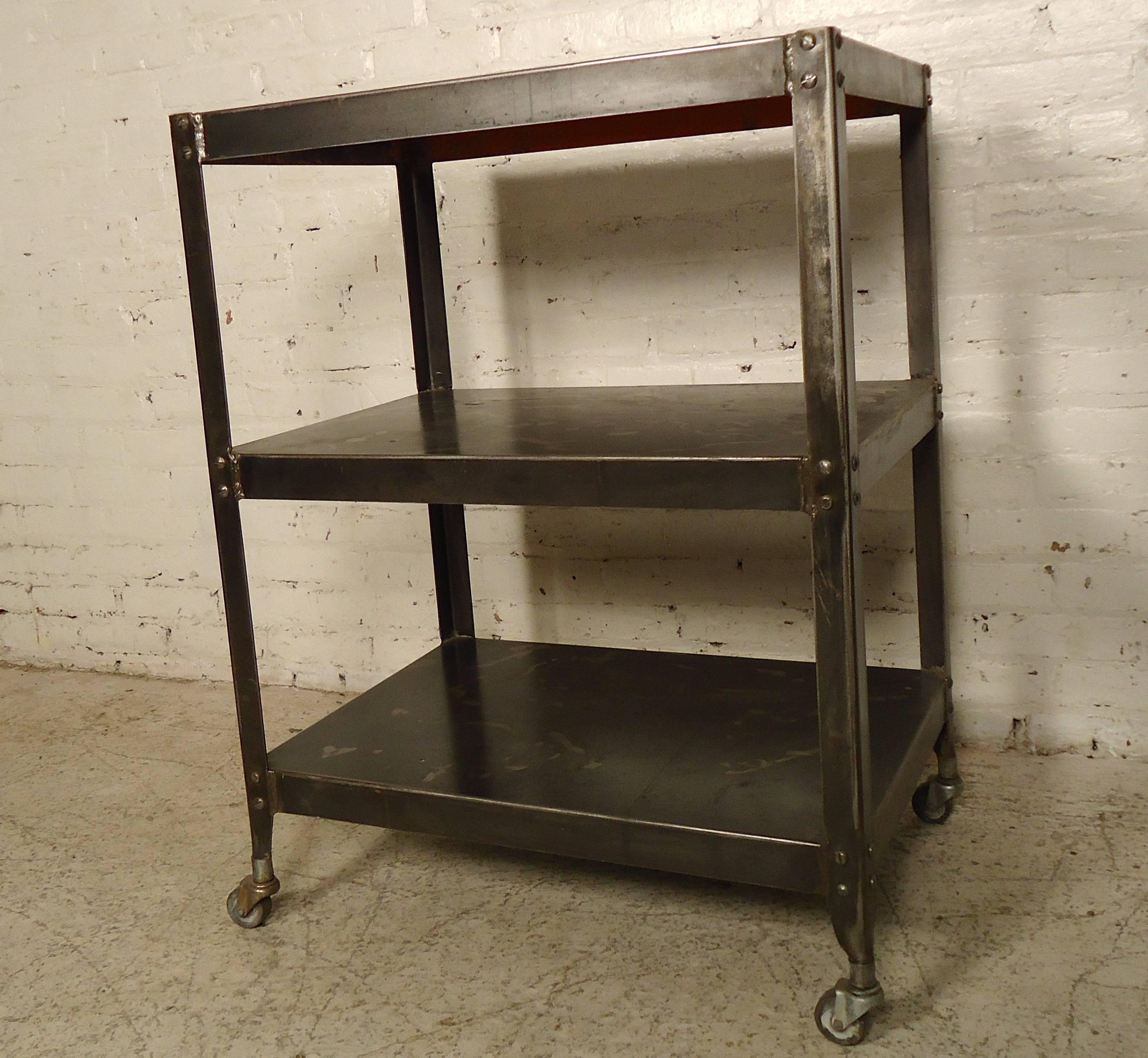 Industrial metal rolling cart with three deep shelves, small caster wheels and heavy Industrial metal. Piece has been stripped and refinished in a bare metal, Industrial style finish.

(Please confirm item location NY or NJ with dealer).
