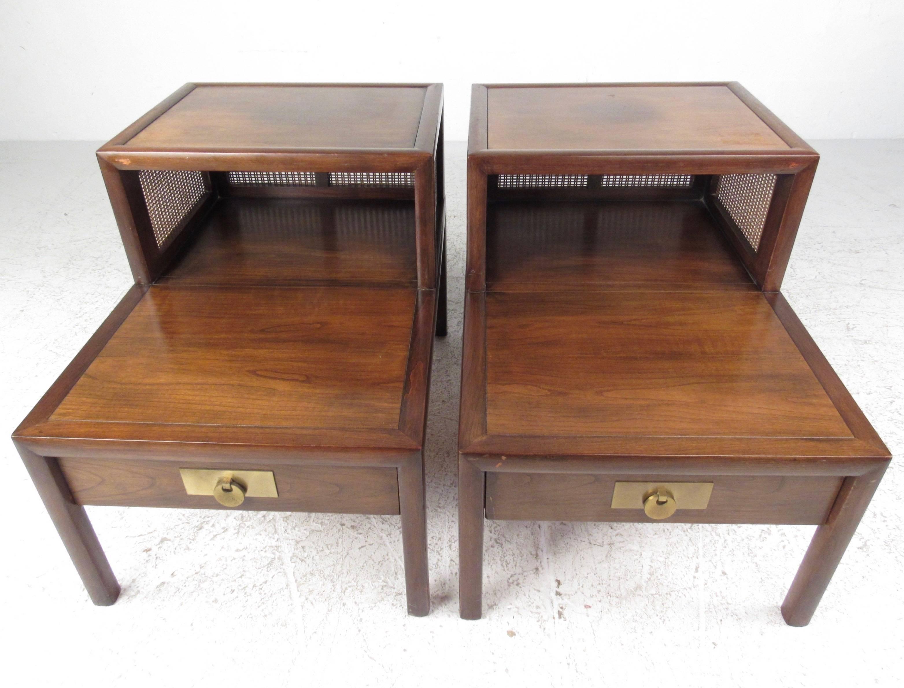 This unique pair of vintage end tables feature two-tier design, brass trim, and cane siding. Rich vintage wood finish makes these a wonderful set of lamp tables in any setting. Please confirm item location (NY or NJ).