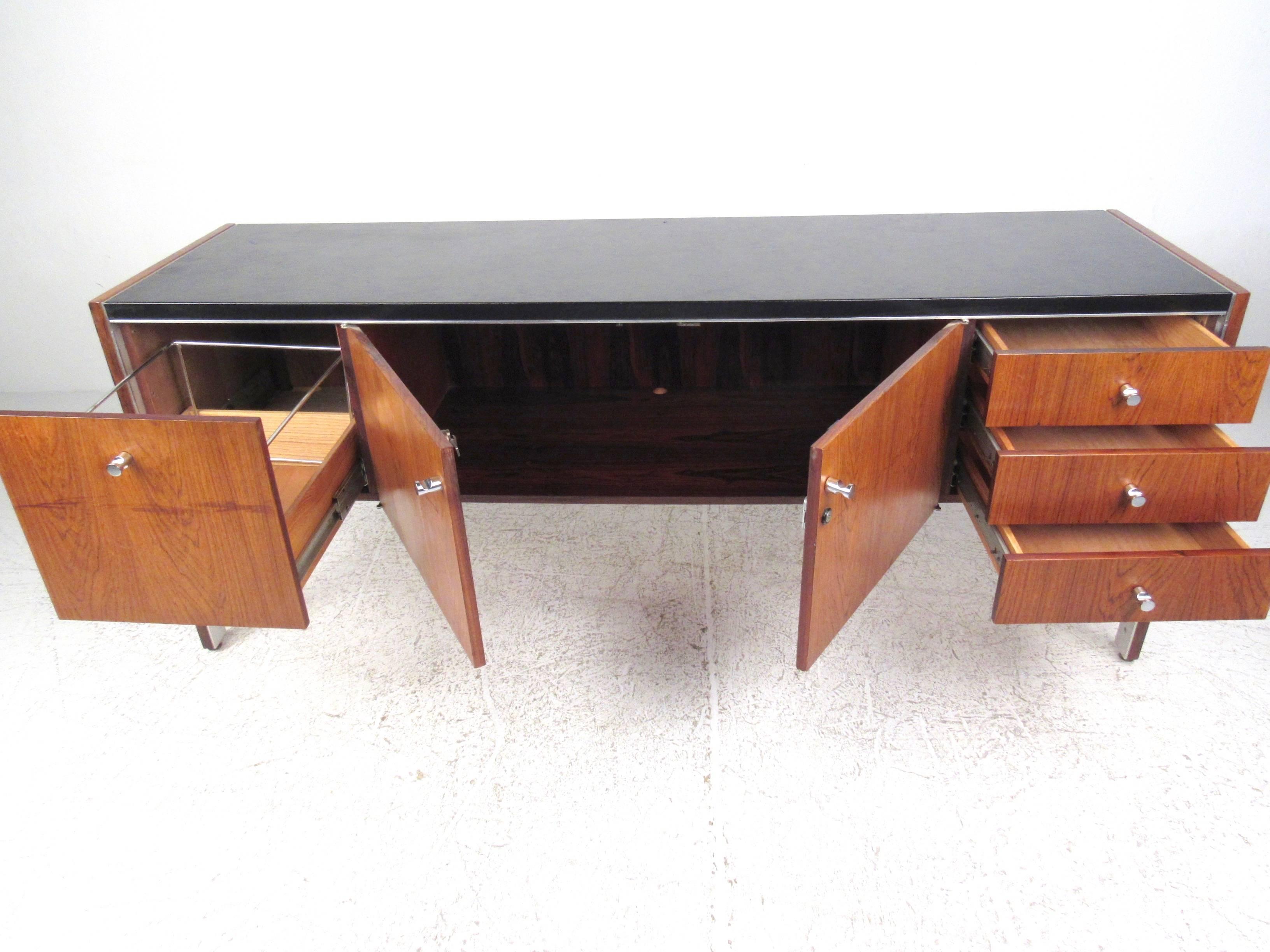 This stunning vintage credenza showcases the fantastic Mid-Century designs of Herman Miller for Biltrite of Canada. Unique late 1960s piece features a leather top and unique chrome trim. Spacious storage cabinet and additional drawers make this a